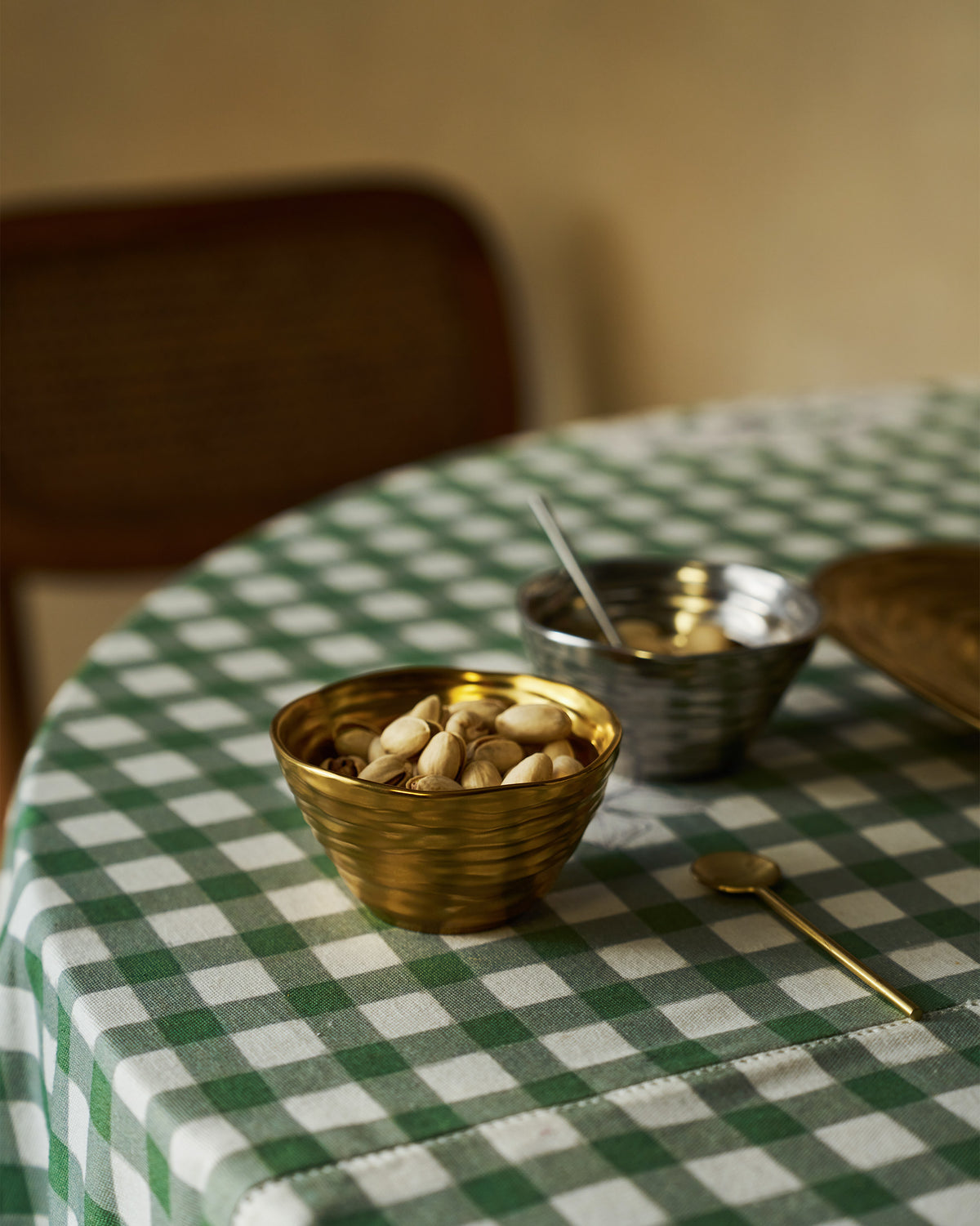 Dhaara nut bowls with nuts on a gingham table.