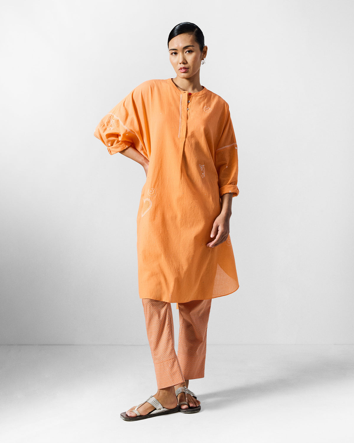 Person wearing an orange Lazy Sunday Tunic Set with matching peach cropped pants.