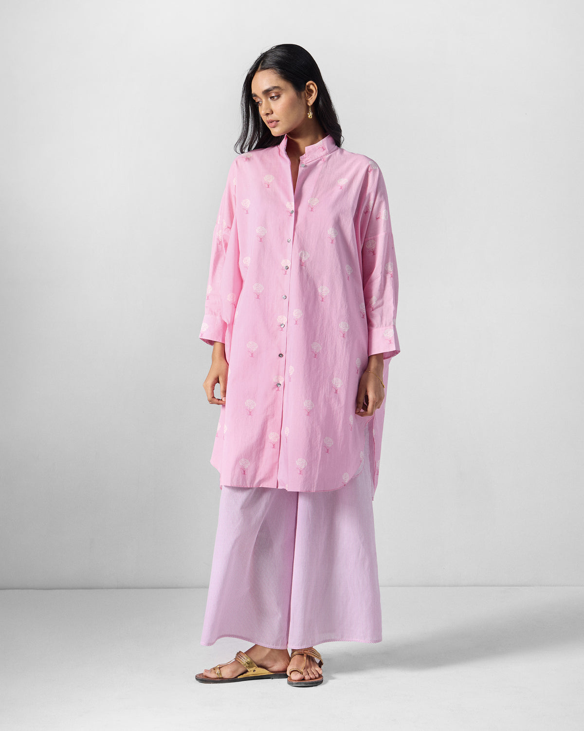 Person wearing a pink floral tunic set with lilac wide-leg pants.