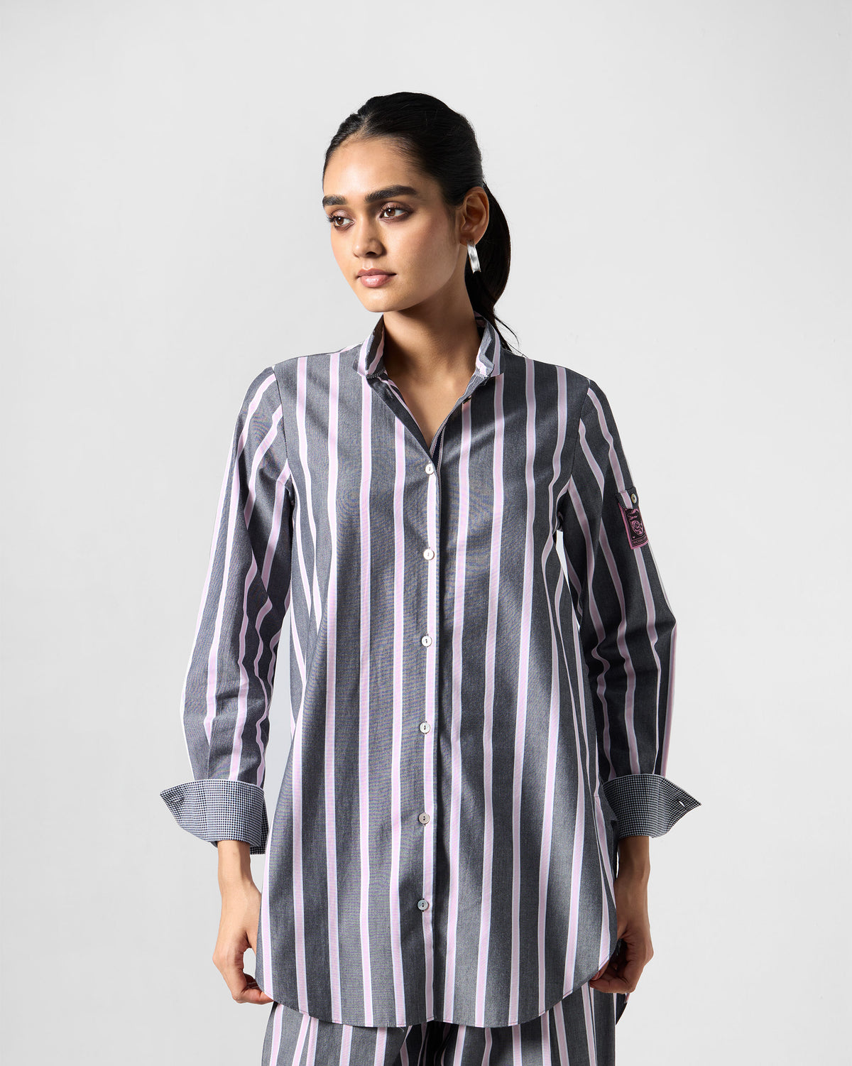 Person wearing a charcoal and pink striped Trench shirt.