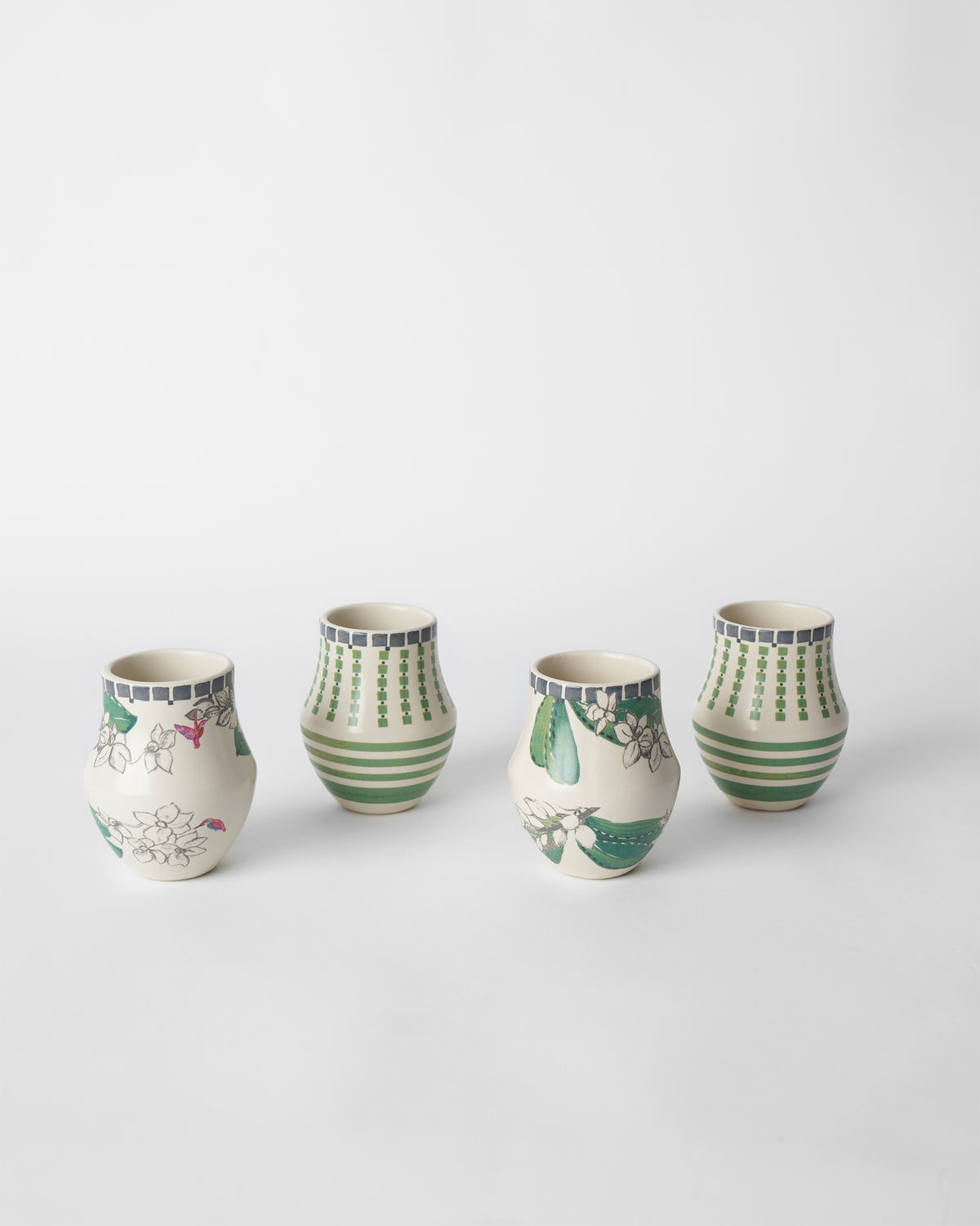 Reesha kulhar set of four with white blossom and green stripe patterns.