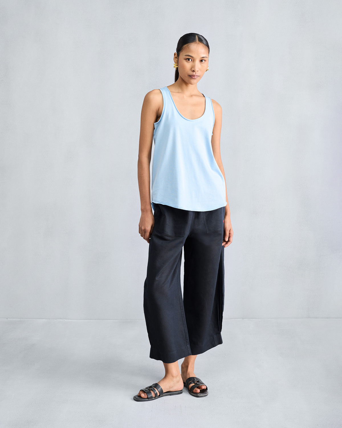 Person wearing a light blue racerback tank in a relaxed fit.