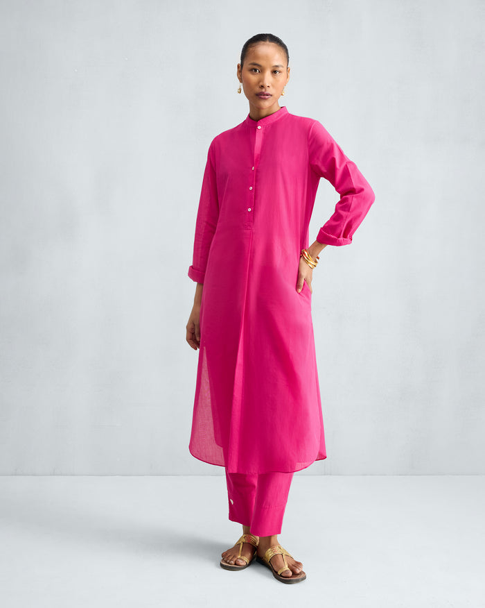 Person wearing a fuchsia long kurta set with a mandarin collar and matching pyjamas.