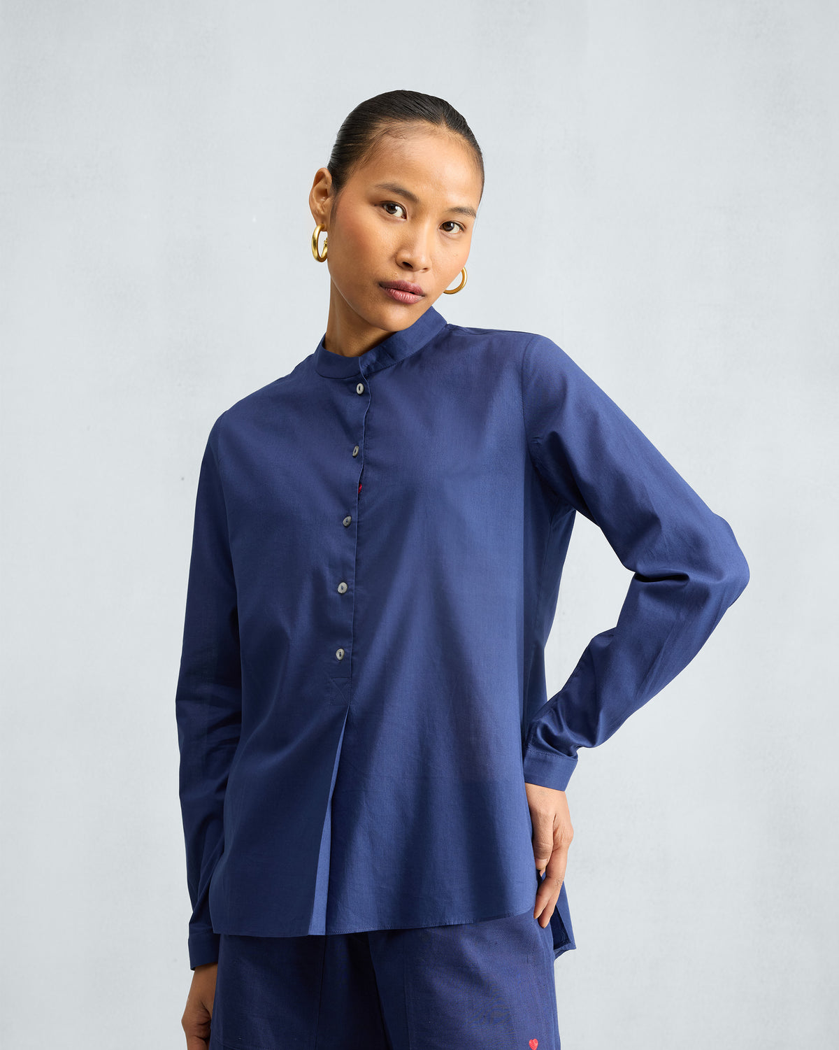 Person wearing an ink blue top set with a red heart on the trouser.
