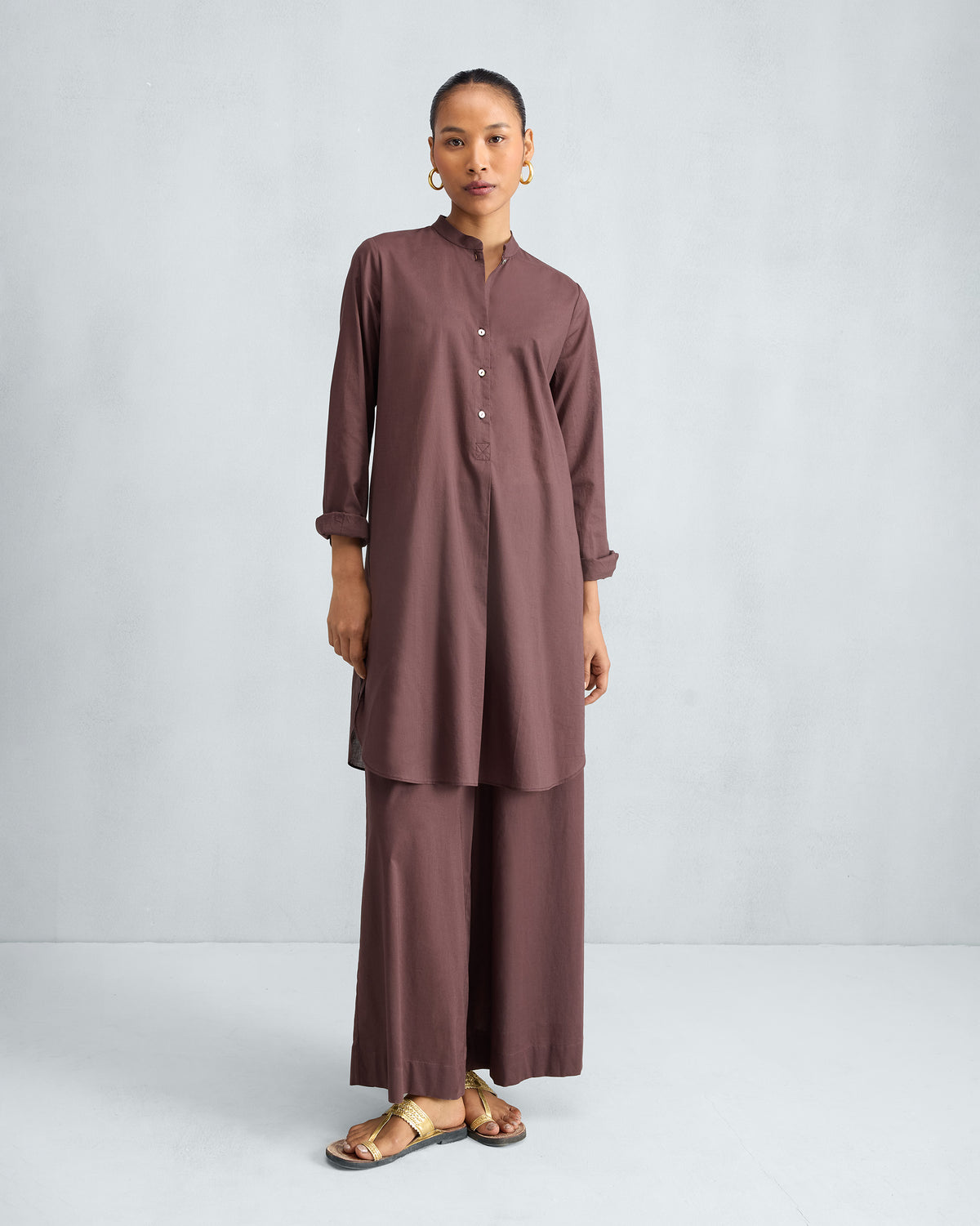 Person wearing a chocolate plum mid-length kurta set with matching wide-leg pyjamas.