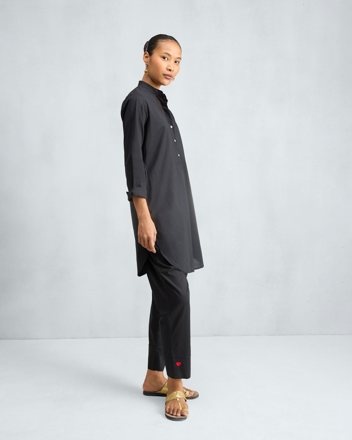 Side view of a black mid-length kurta set with matching pants.