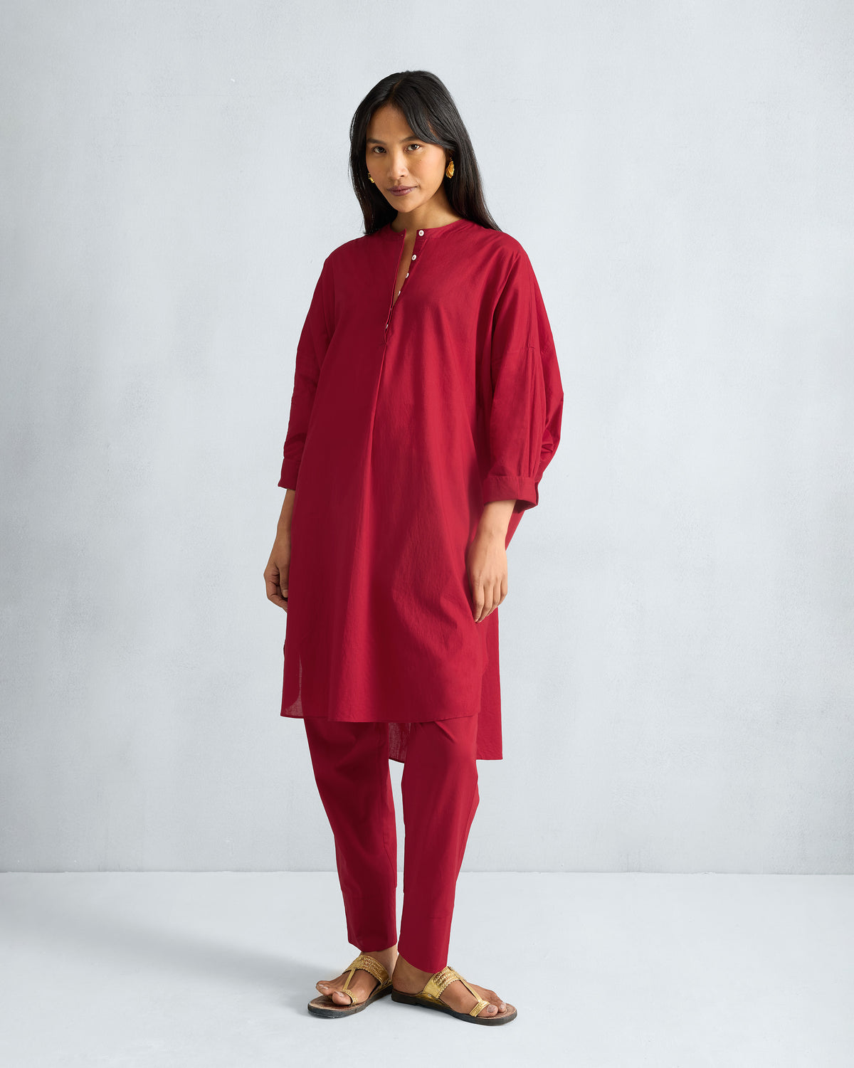Person wearing a red Lazy Sunday tunic set with mandarin collar and matching pants.