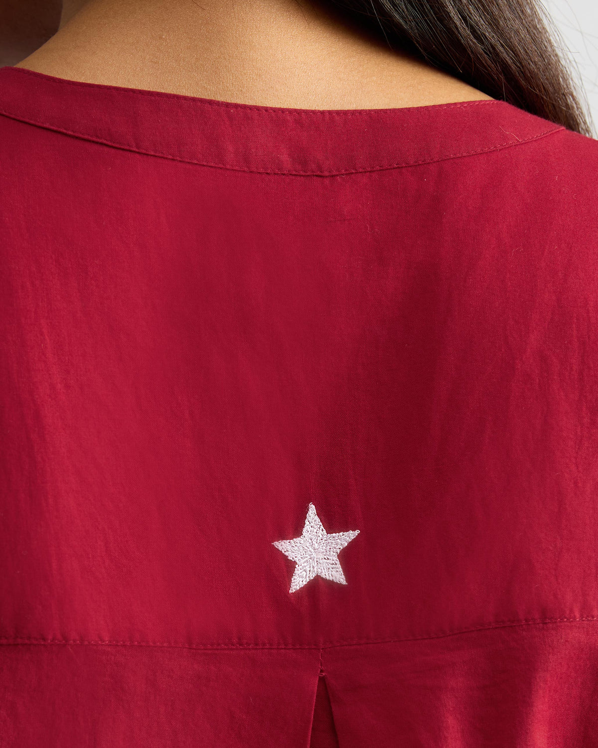 Close-up of the white star embroidery on a red Lazy Sunday tunic.