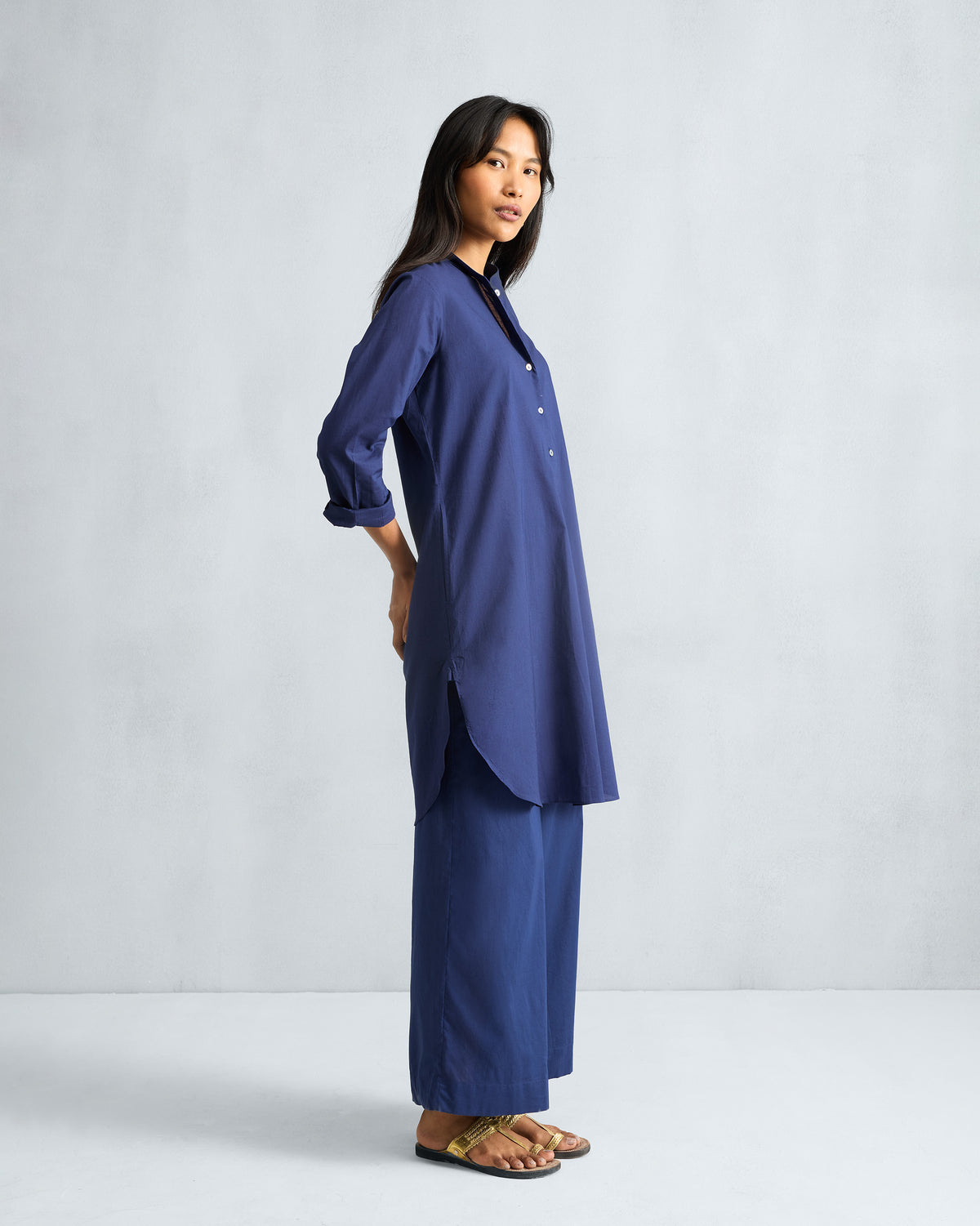 Side view of an ink blue mid-length kurta set showing the side slits.