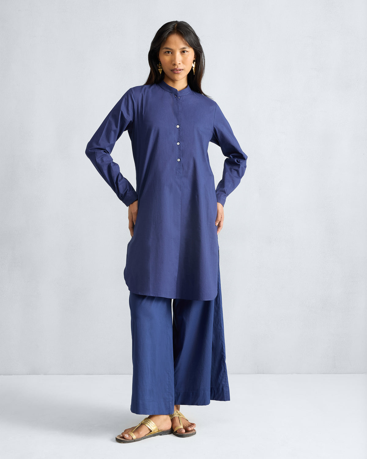 Person wearing an ink blue mid-length kurta set with full sleeves.
