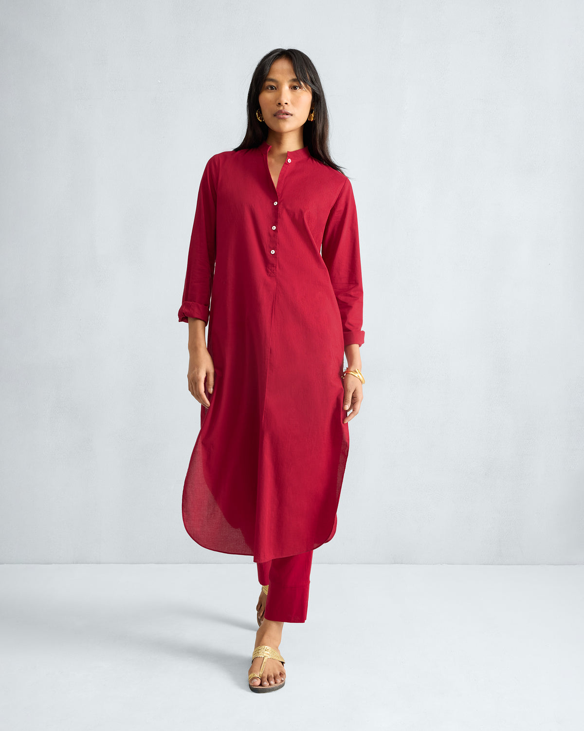 Person wearing a red long kurta set with a mandarin collar and matching pants.