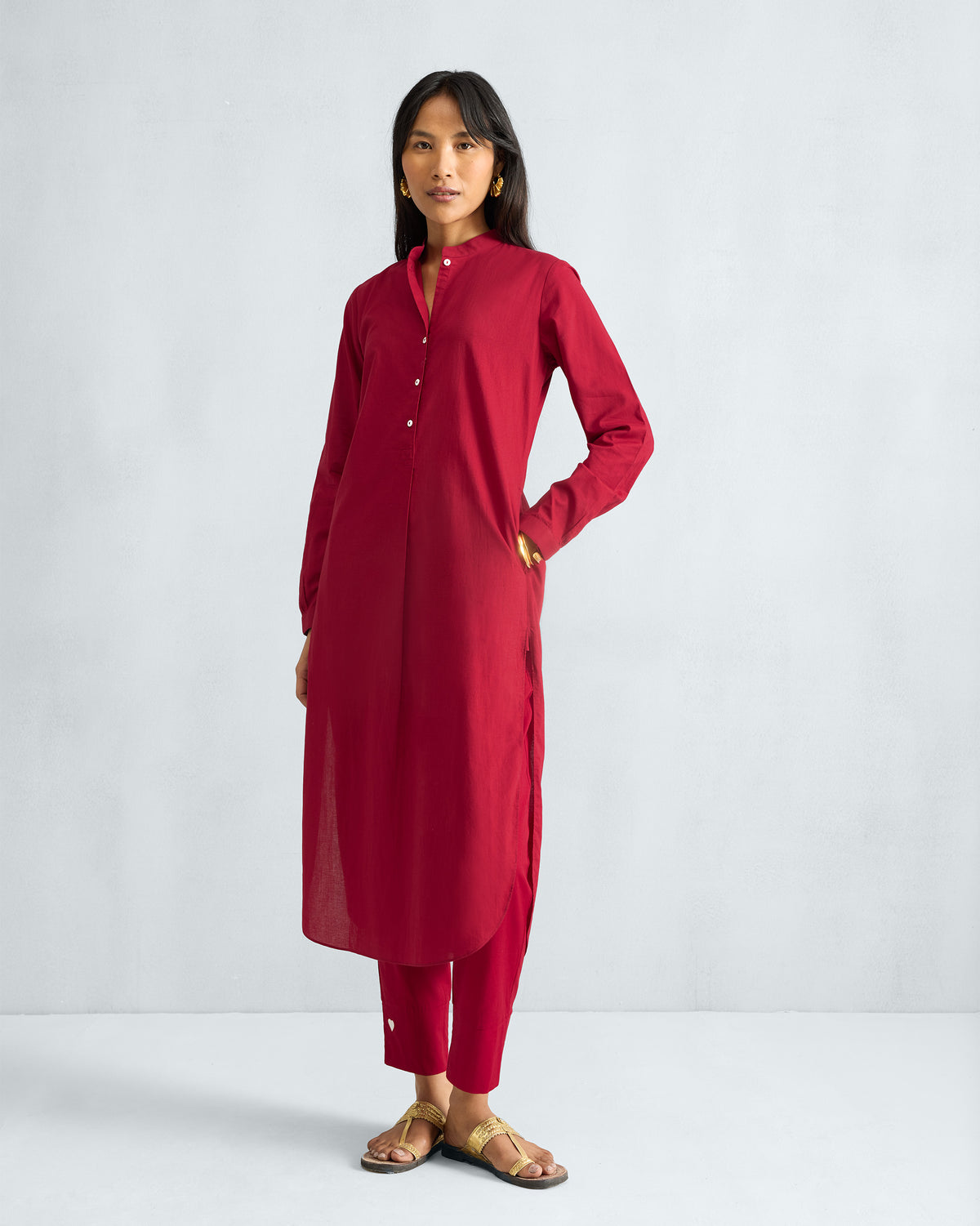 Three-quarter view of a red long kurta set with matching pants.