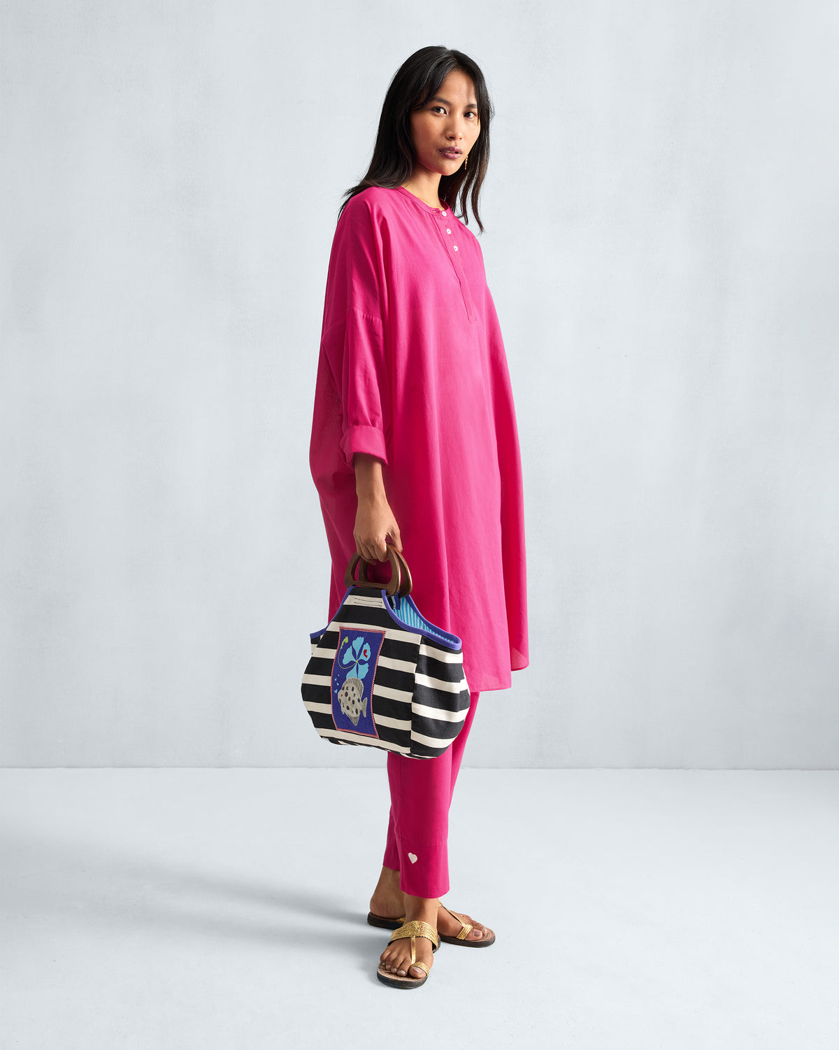 Person wearing a fuchsia Lazy Sunday Tunic Set with a white heart on the pant hem.