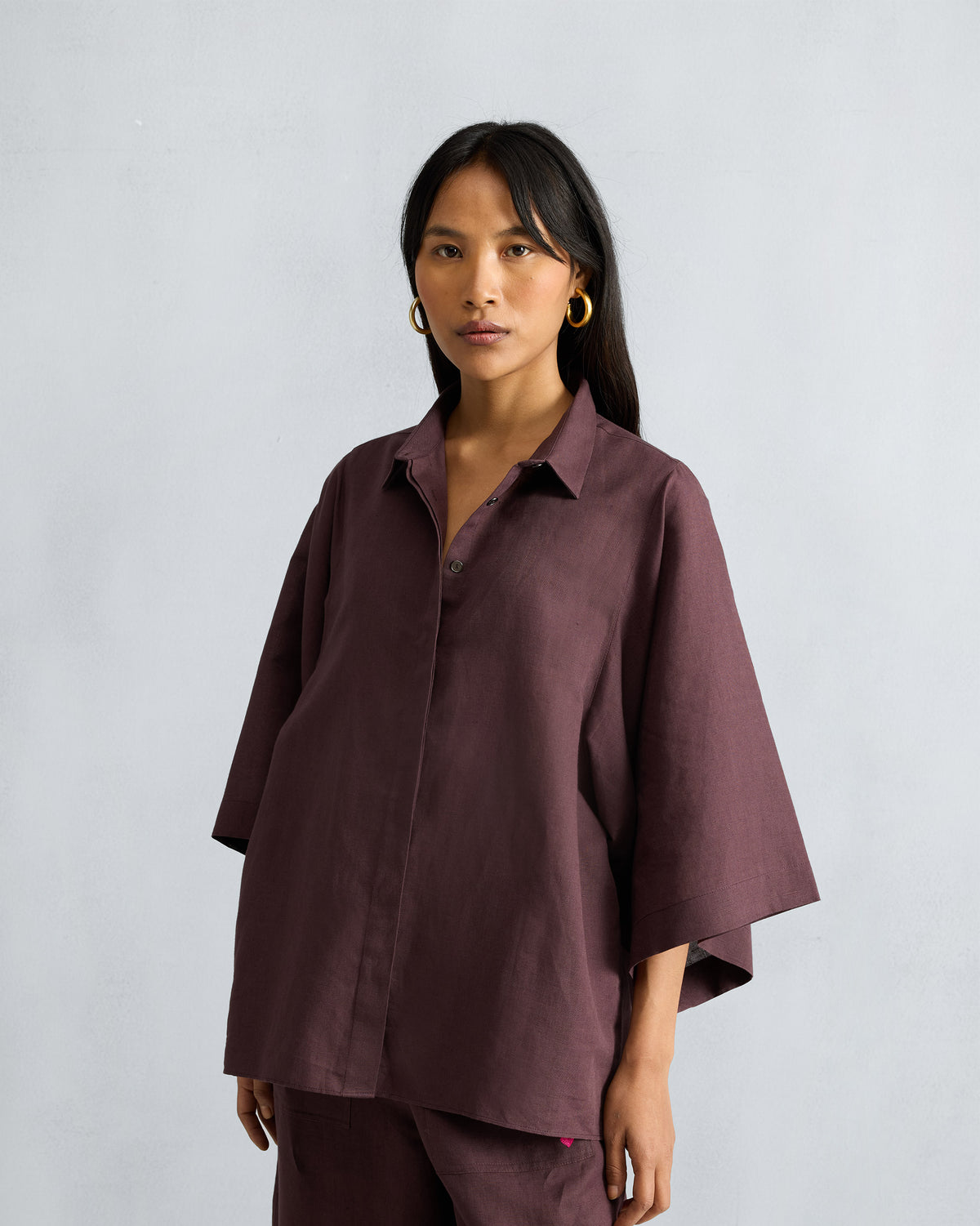 Chocolate plum drop-armhole shirt with wide three-quarter sleeves.