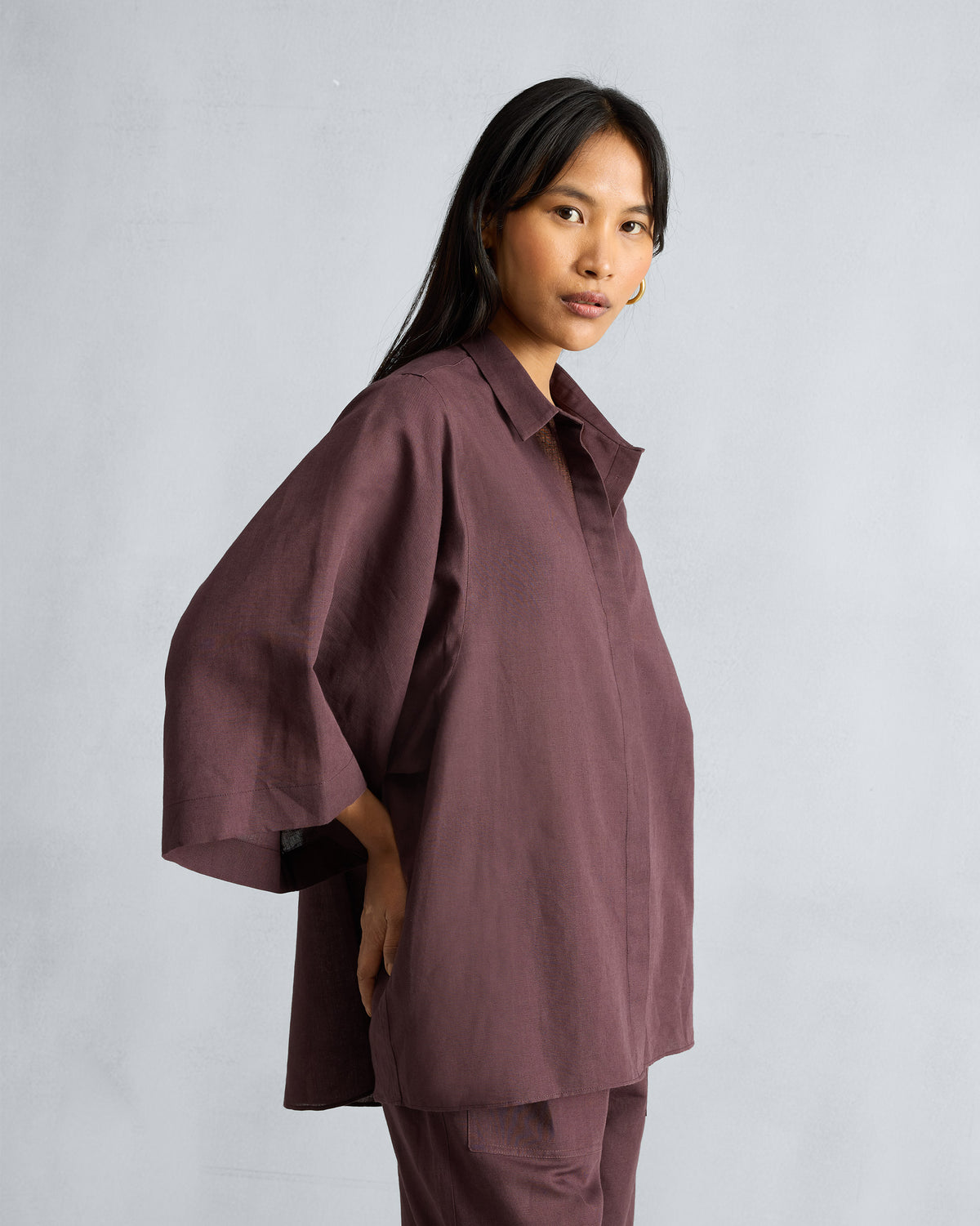 Three-quarter view of a chocolate plum drop-armhole shirt set.