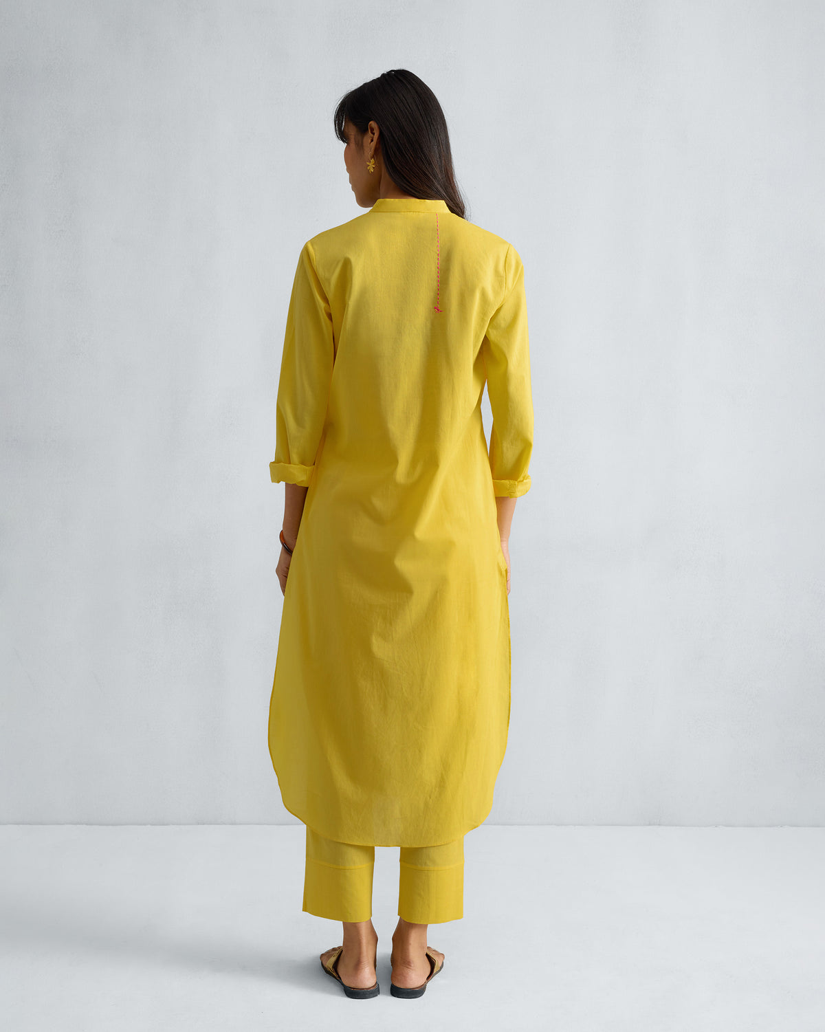 Back of a yellow long kurta set with a pink embroidered back detail.