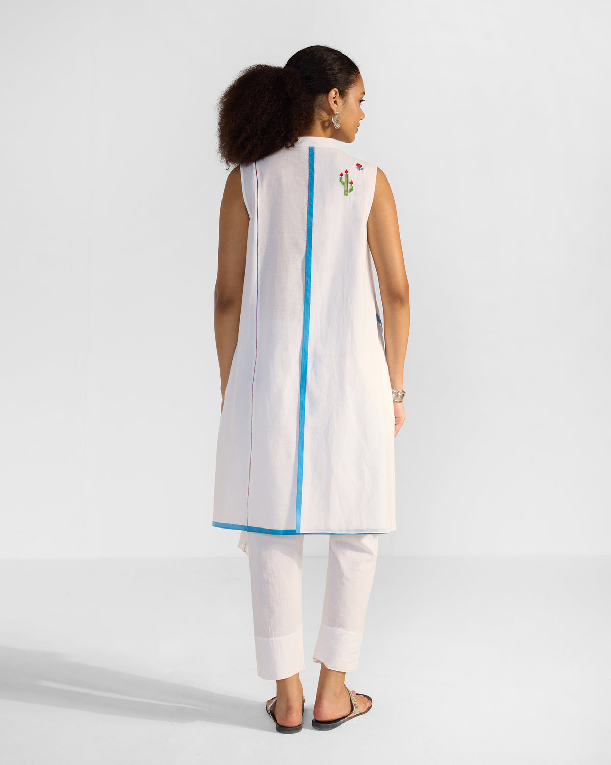 Back of a white Riha kurta with a blue centre strip and cactus embroidery.