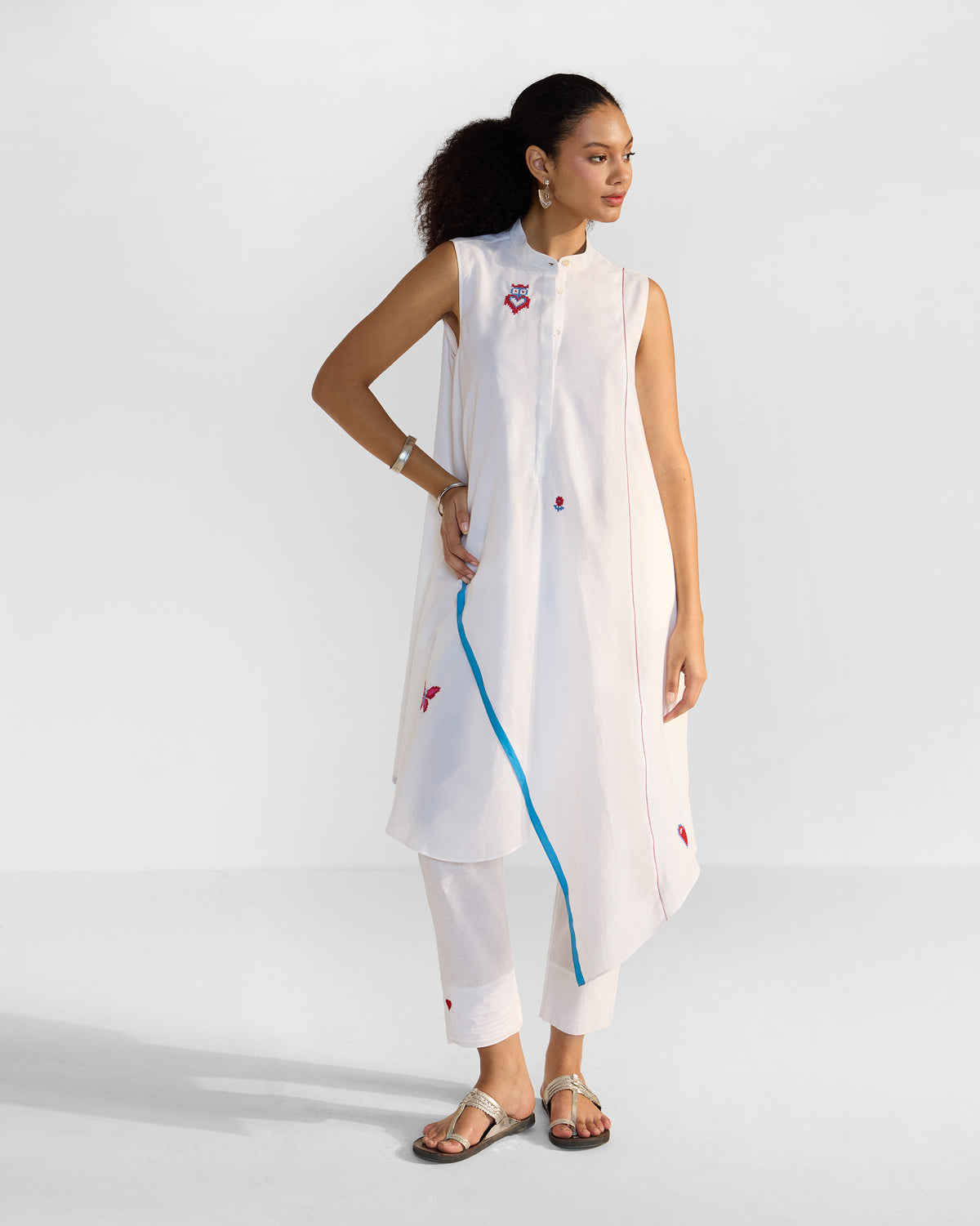 Person wearing a white Riha Kurta Set with an asymmetric hem and blue selvedge.