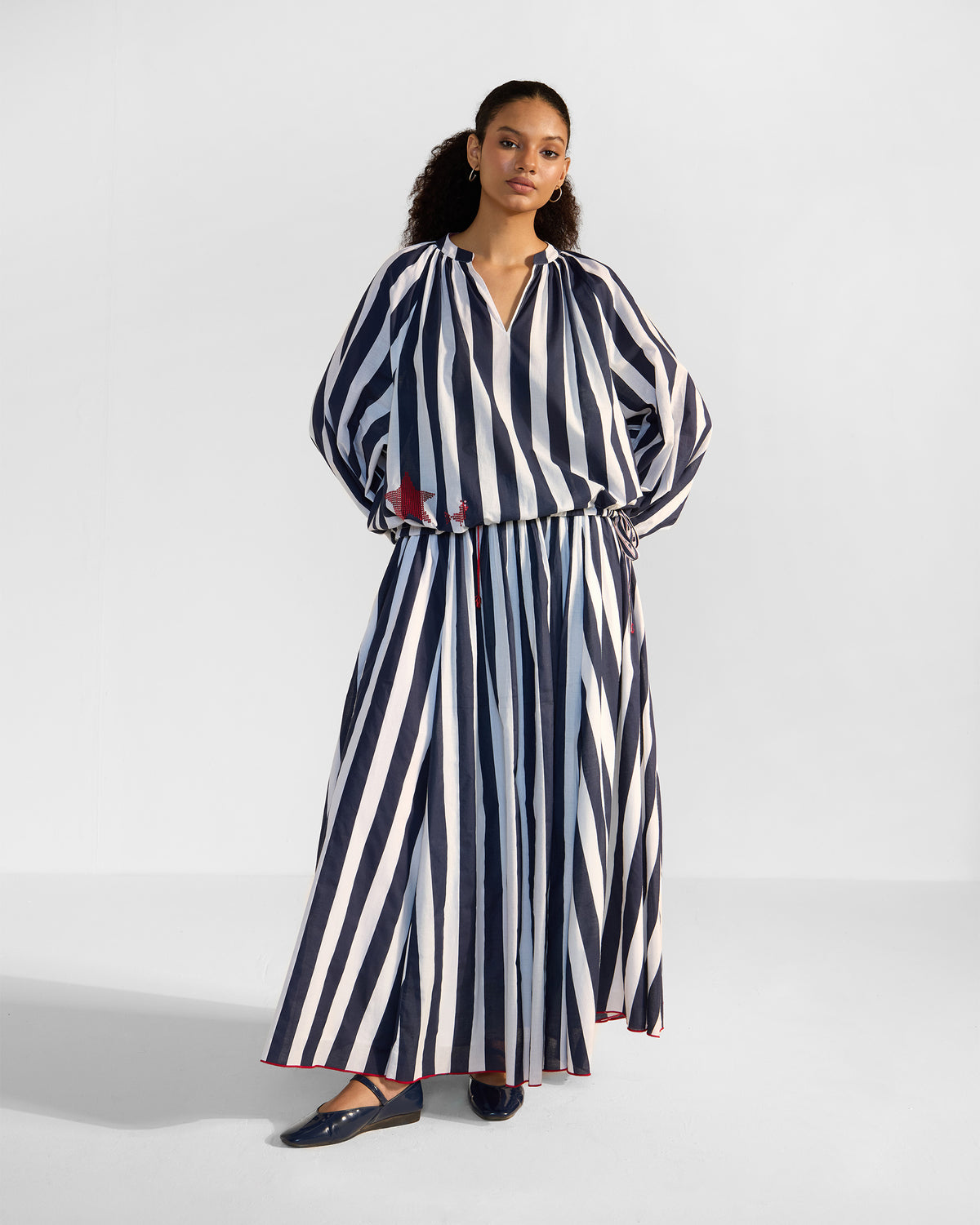 Person wearing a navy and white striped Zaya Top Set with a red sequin star.