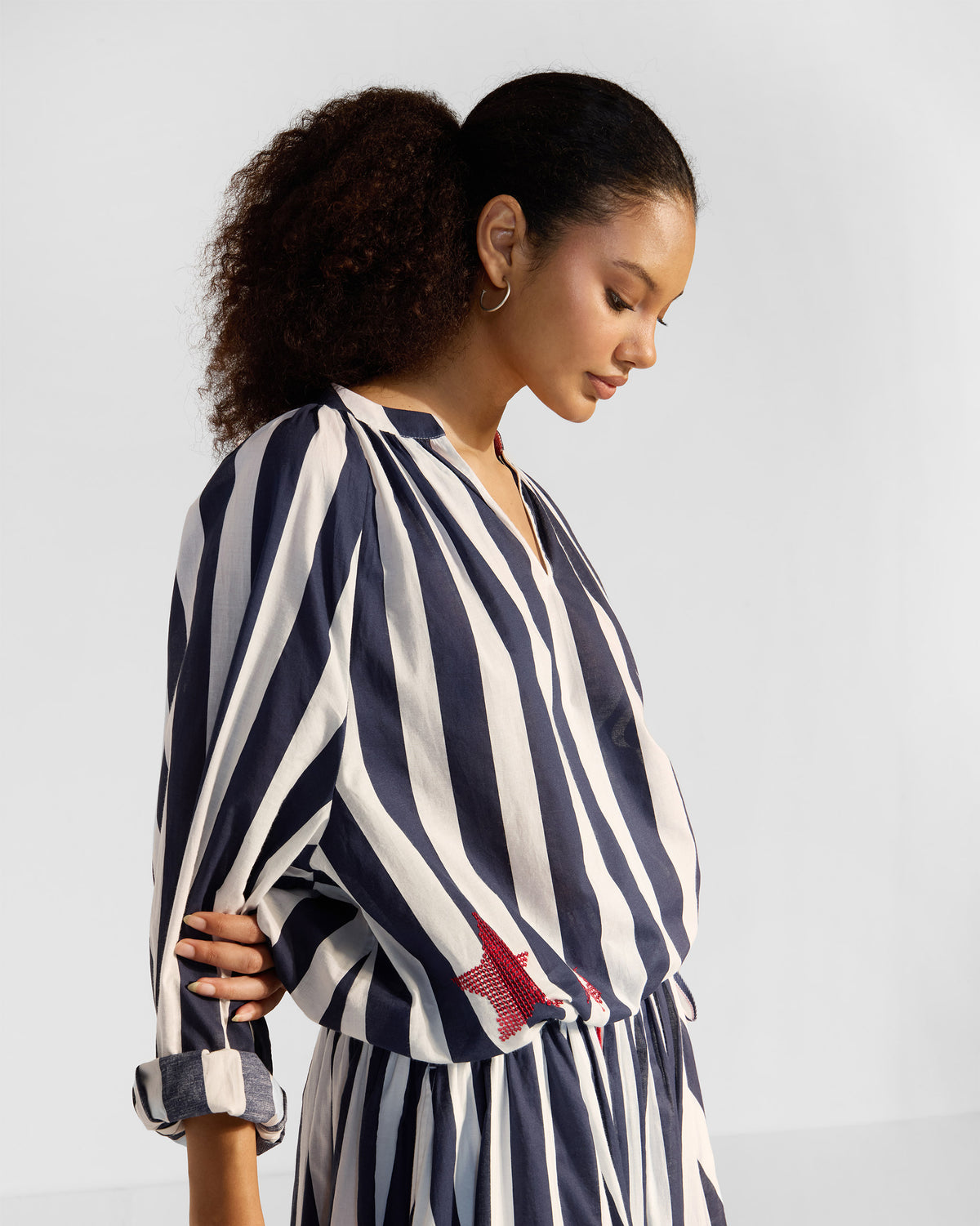 Side view of a navy and white striped Zaya top with a red sequin star.