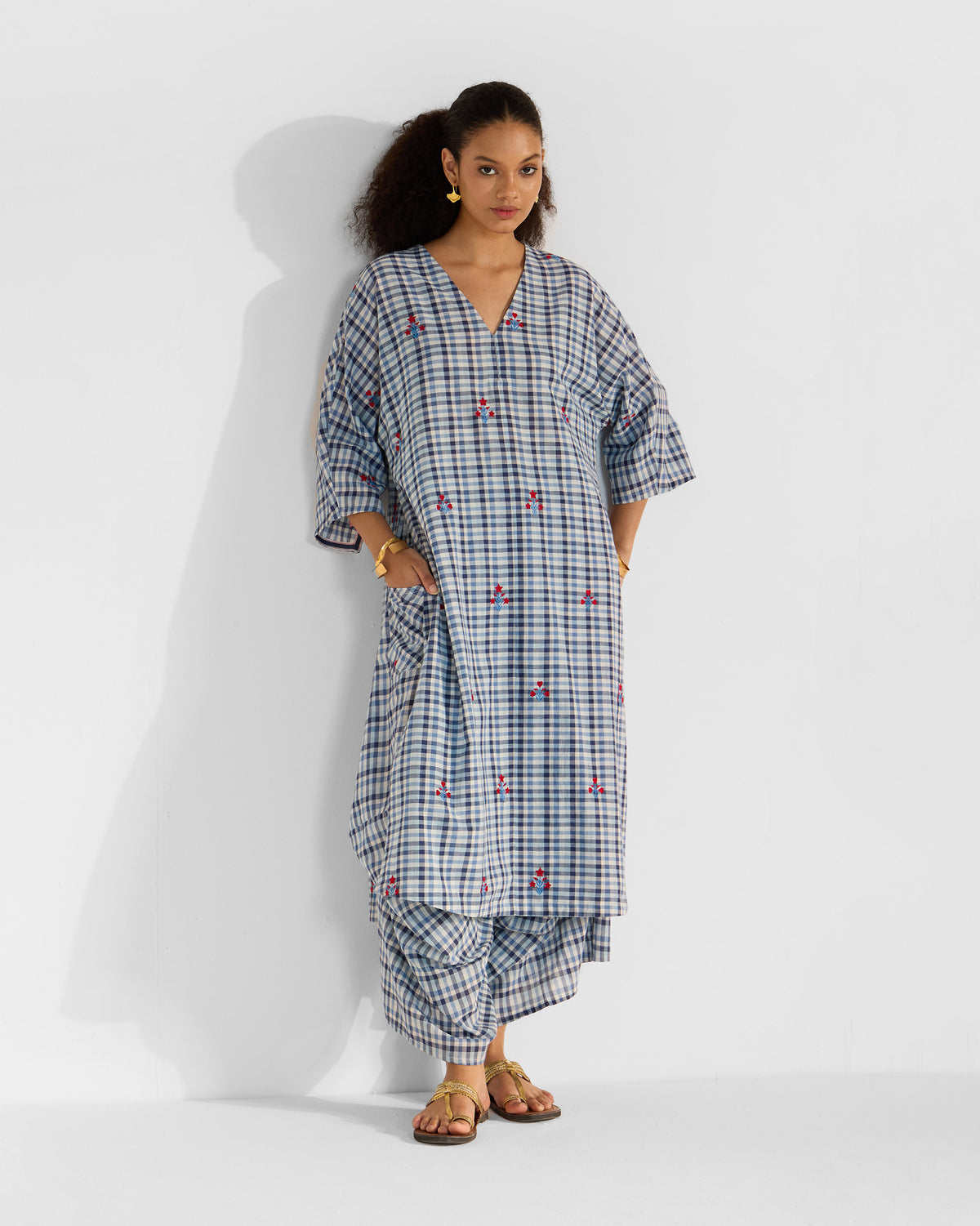 Person wearing a blue and white check Aava kurta set with scattered red embroidery.
