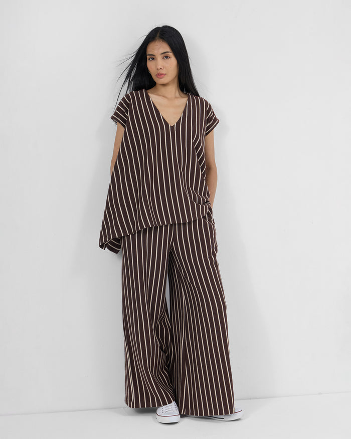 Person wearing a brown and ivory striped Nera kaftan top set with matching pants.