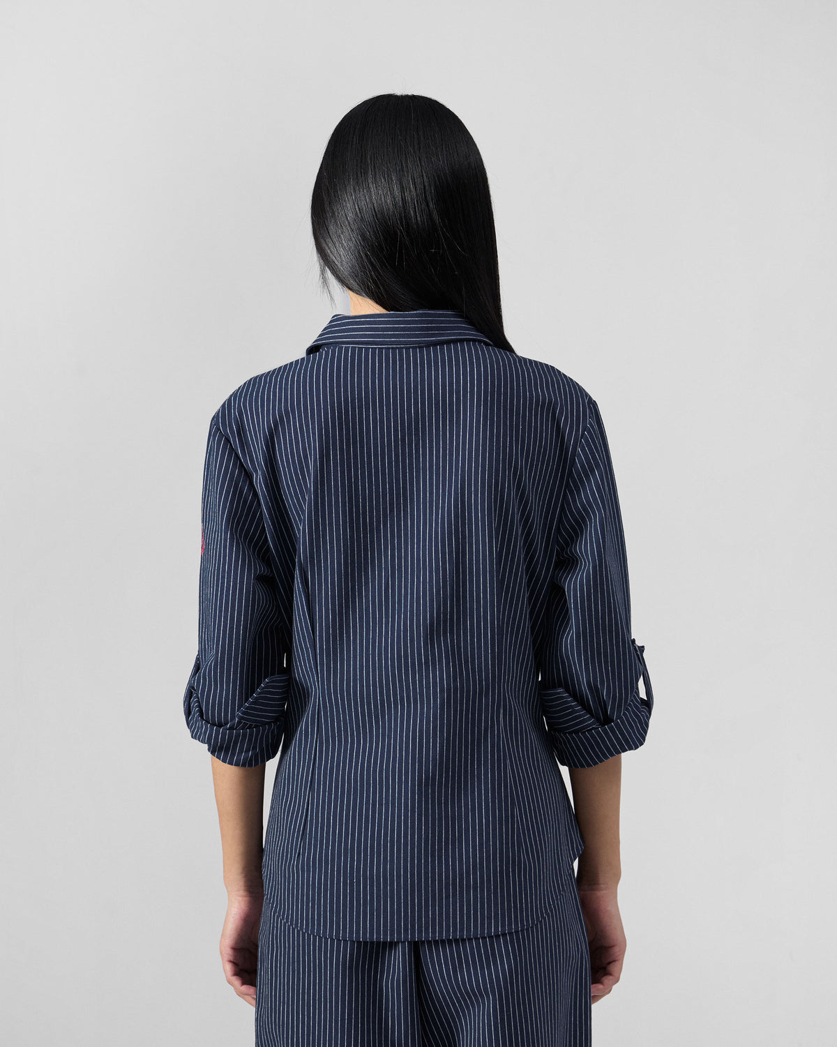 Back of a navy pinstripe Kalo Shirt Set with rolled sleeves.