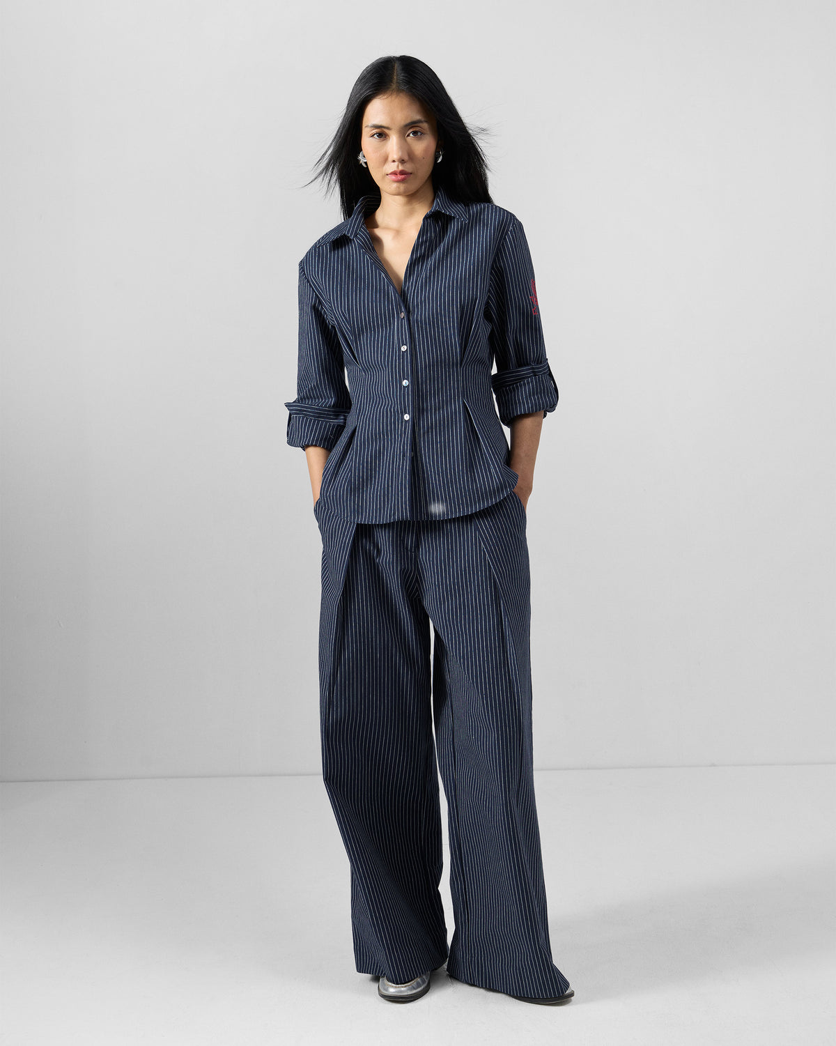 Person wearing a navy pinstripe Kalo Shirt Set with wide-leg trousers.