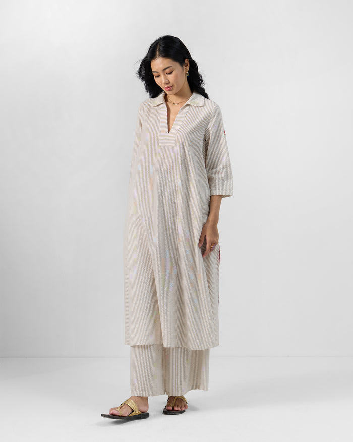 Person wearing a brown and ivory striped Maner Kurta Set with a deep V-neck.