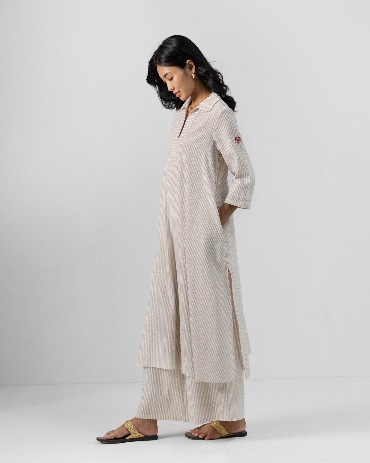 Person wearing a brown and ivory striped Maner Kurta Set with hands in the pockets.