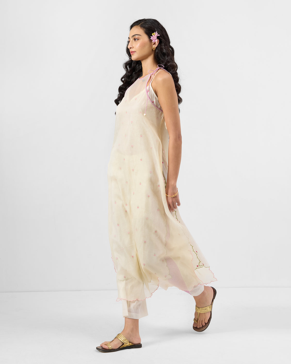 Side view of an ivory Hera Halter Kurta Set with a scalloped hem over trousers.