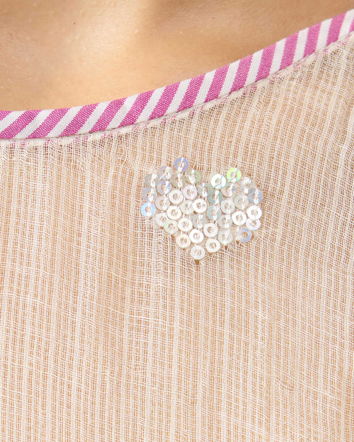 Close-up of a sequin heart on an ivory Hera Halter Kurta Set with striped neckline trim.