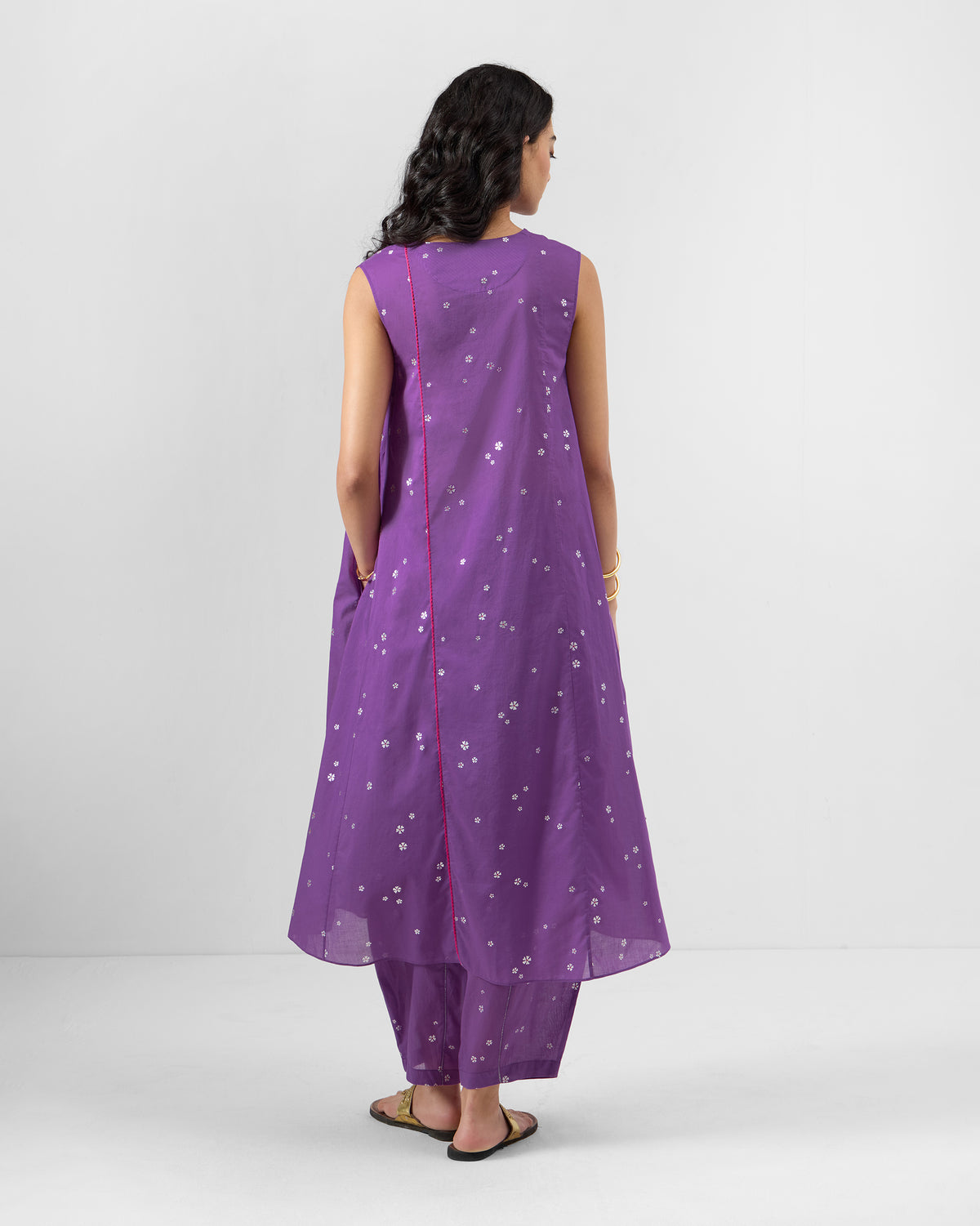 Back of a purple floral kurta with pink piping.