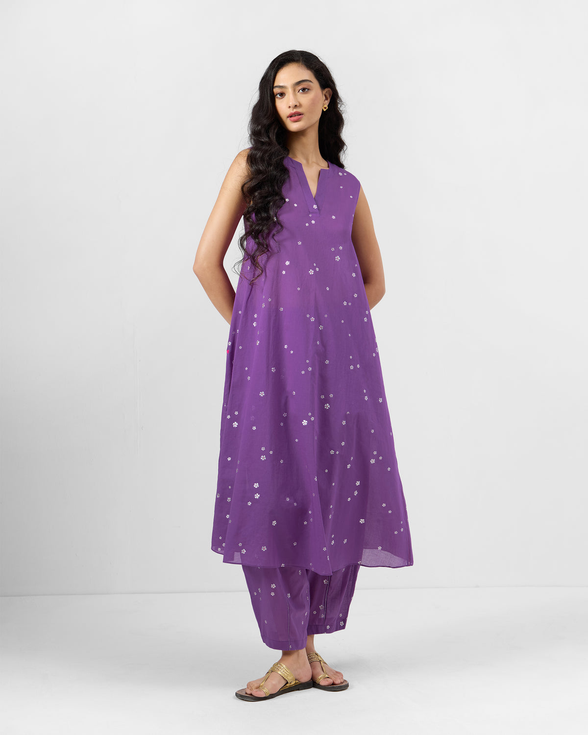 Person wearing a purple floral sleeveless kurta set.
