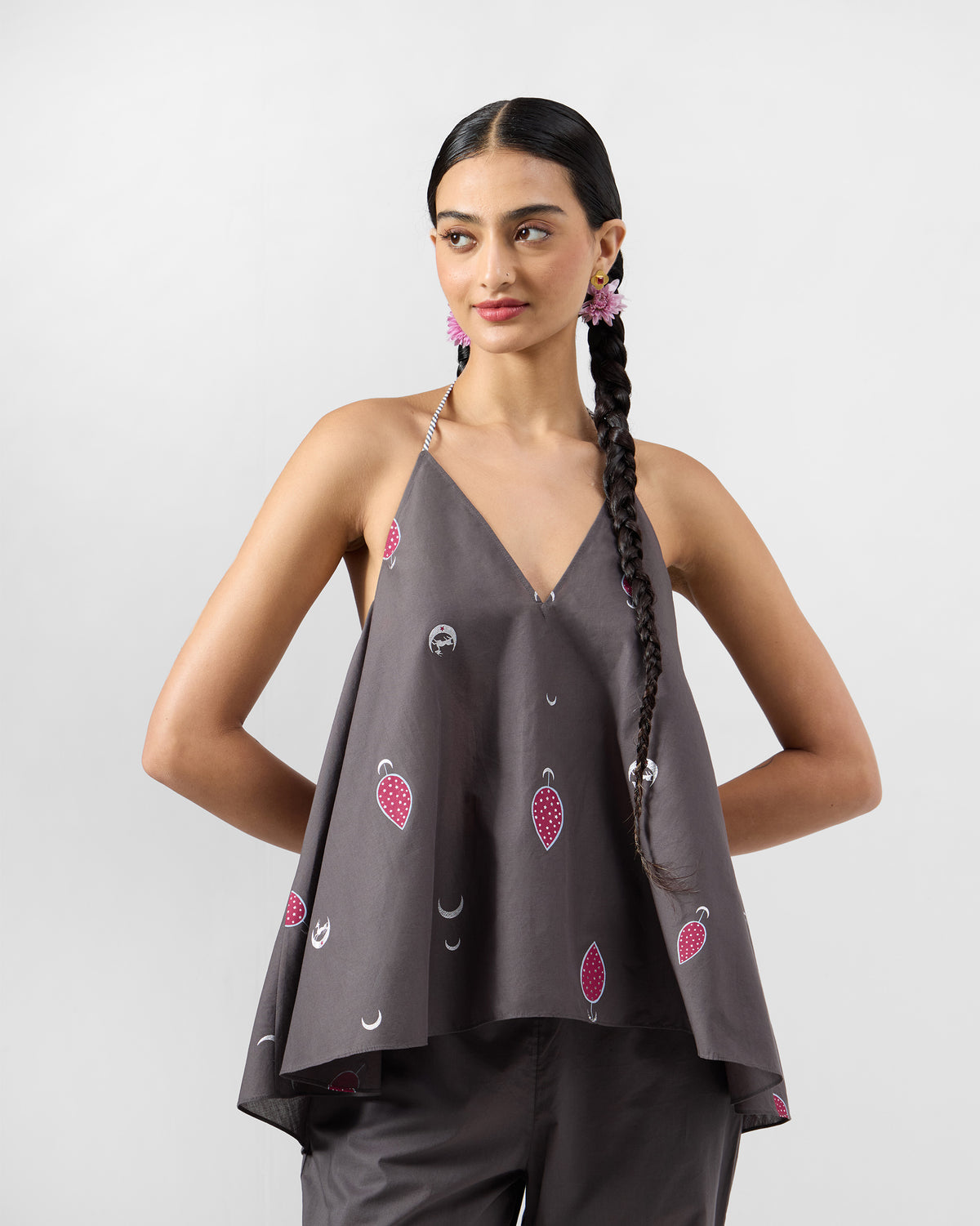 Person wearing a flared charcoal Daman top with pink teardrop motifs.