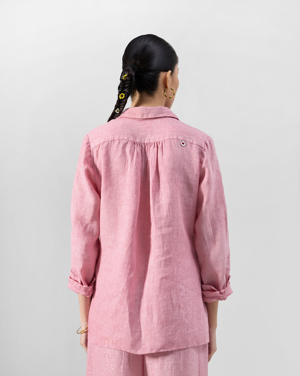 Back of a dusty pink Mati shirt with a small heart charm.