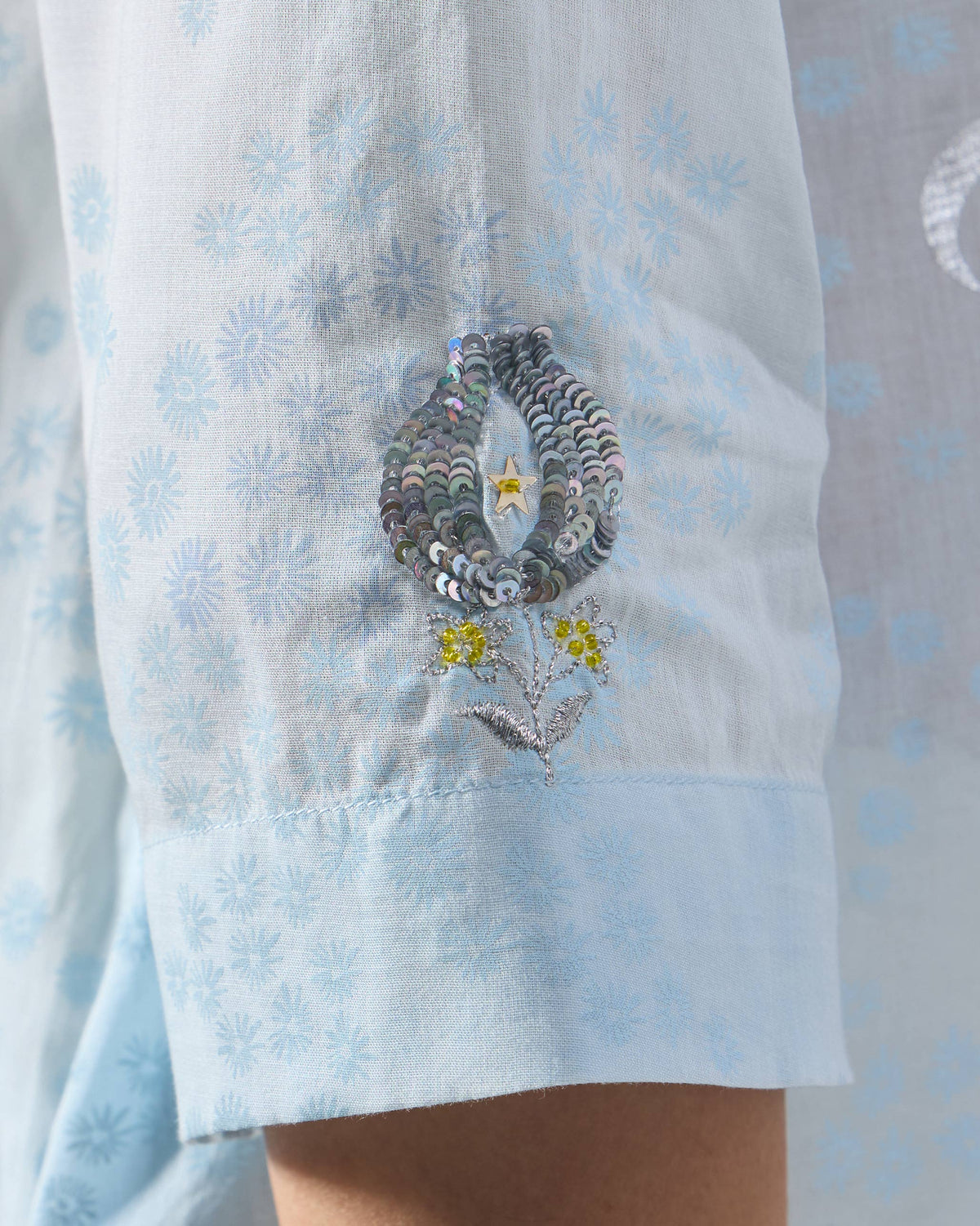 Close-up of rainbow sequin embroidery on a pale blue Kolva Kurta sleeve.