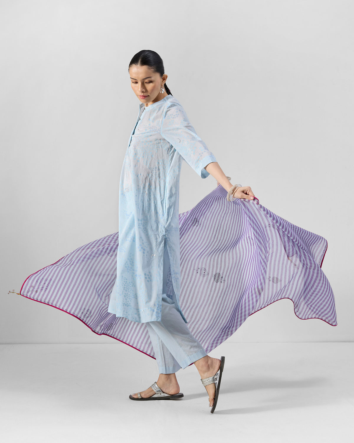 Person wearing a pale blue Kolva Kurta Set with a striped purple dupatta.