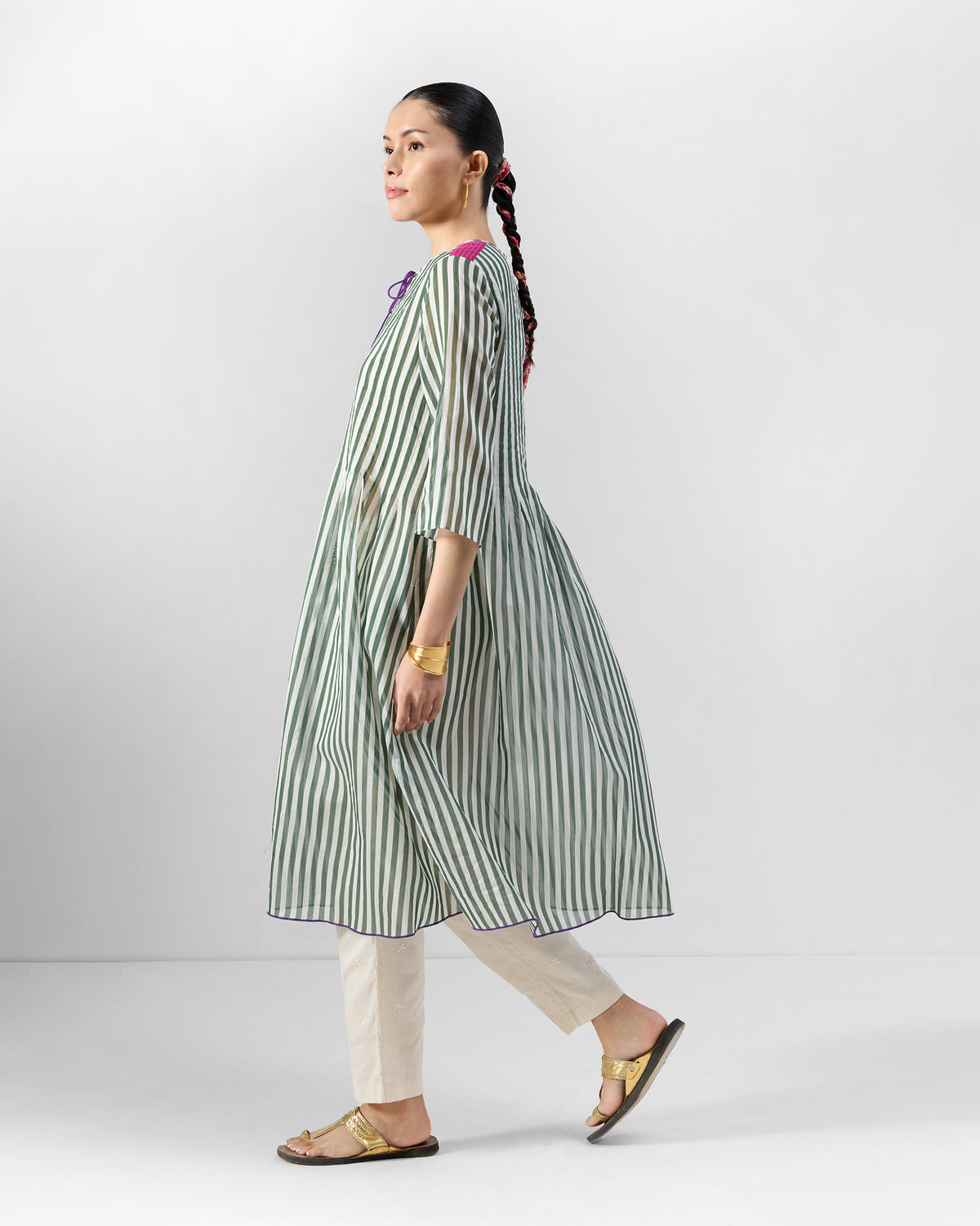 Person wearing a green striped kurta set with trousers.