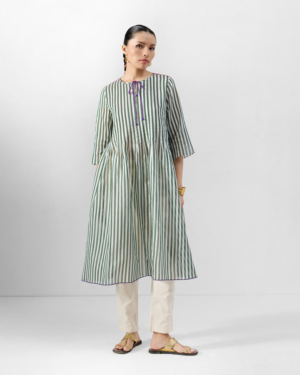 Person wearing a green striped kurta set with trousers.