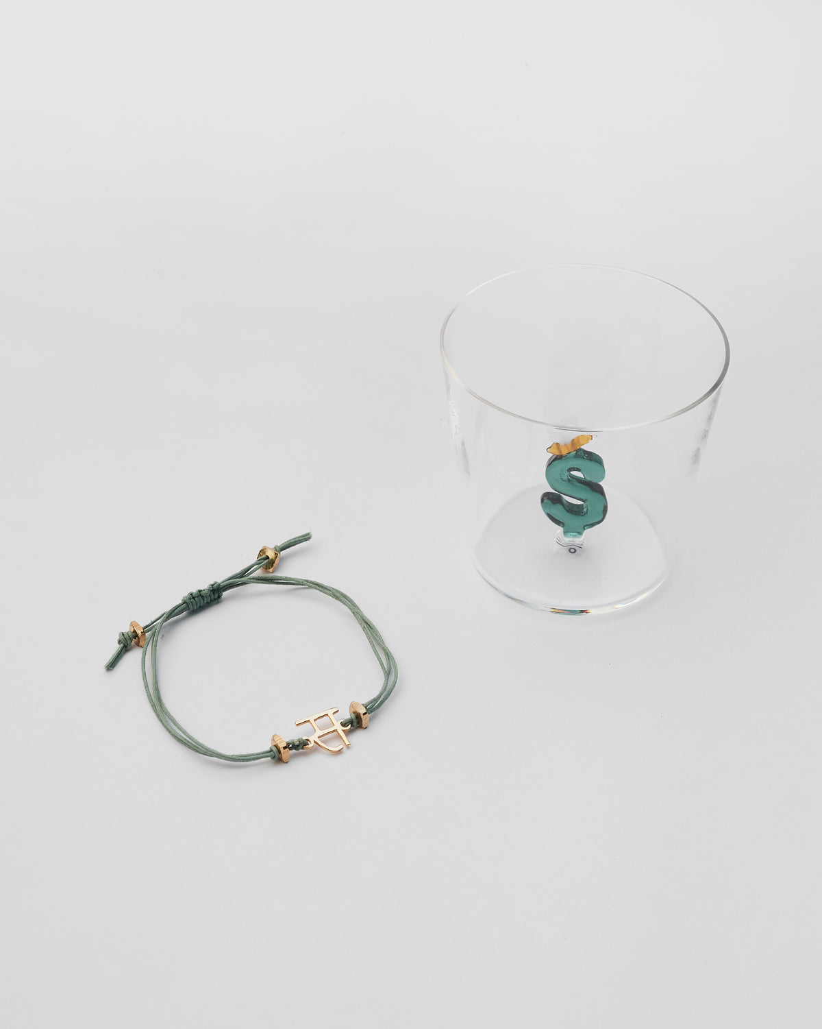 Alphabet S rakhi beside a glass with a letter S.