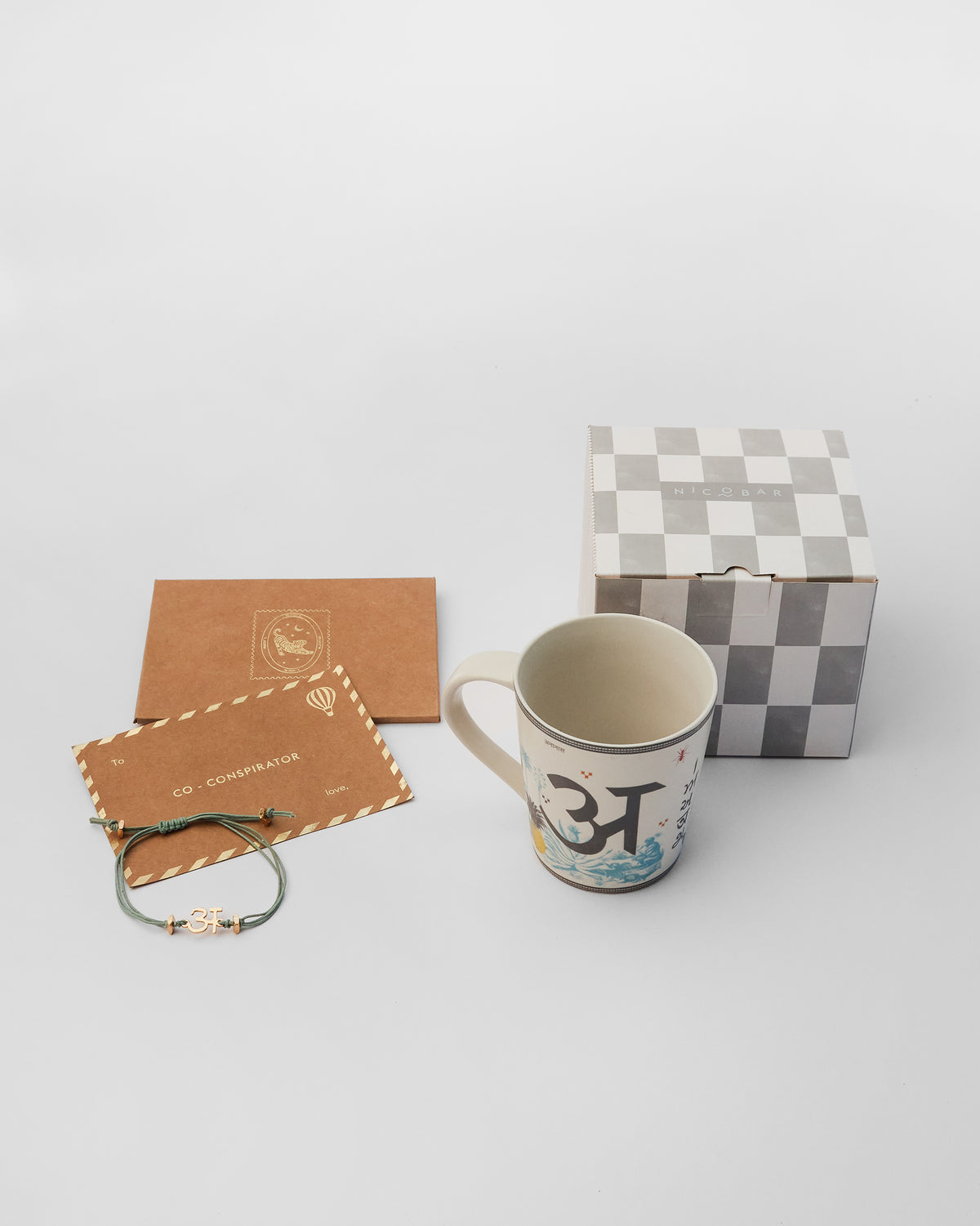 Ananas rakhi set with mug, letter A rakhi, and gift box.