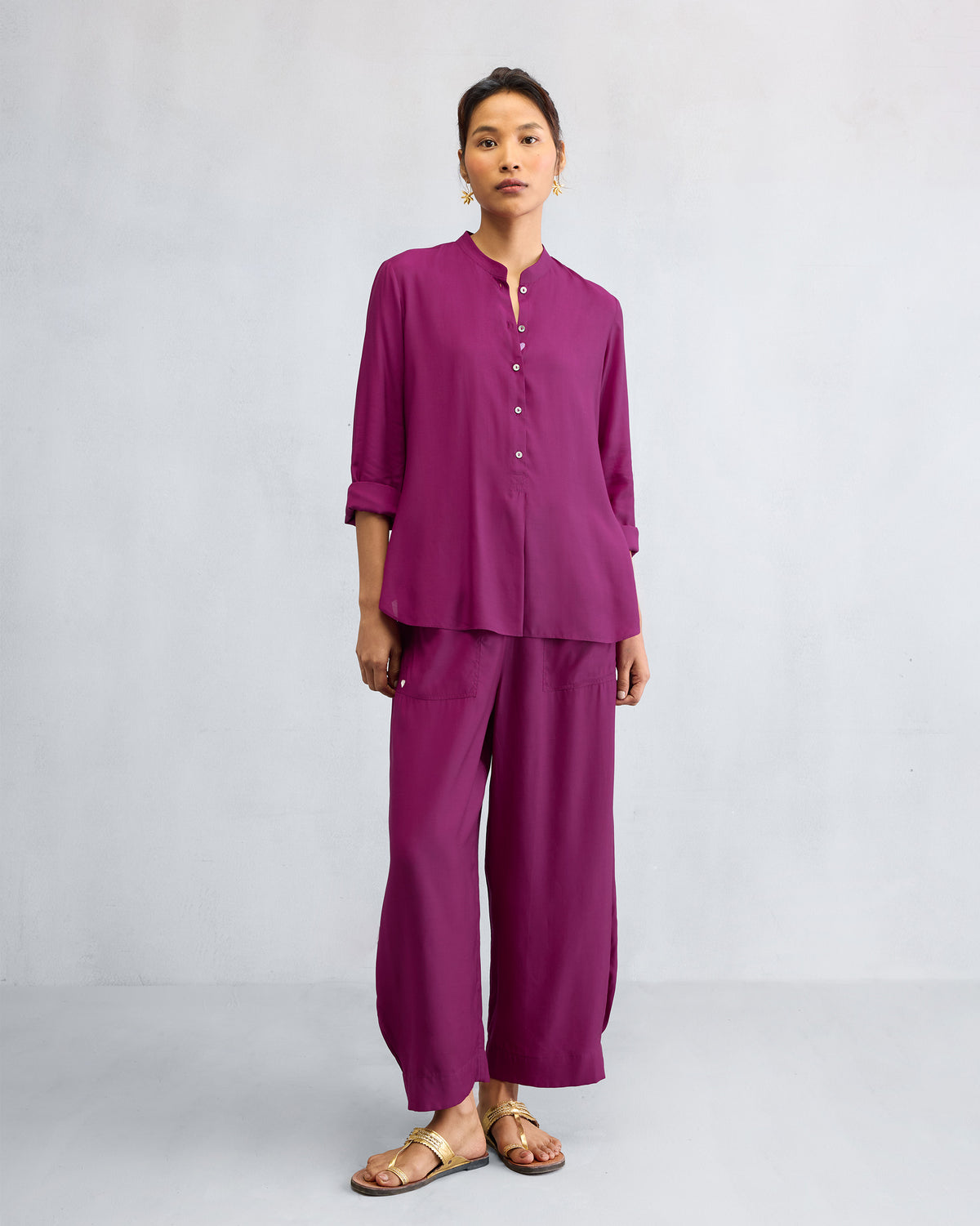 Person wearing a mulberry mandarin collar top set with matching wide pants.