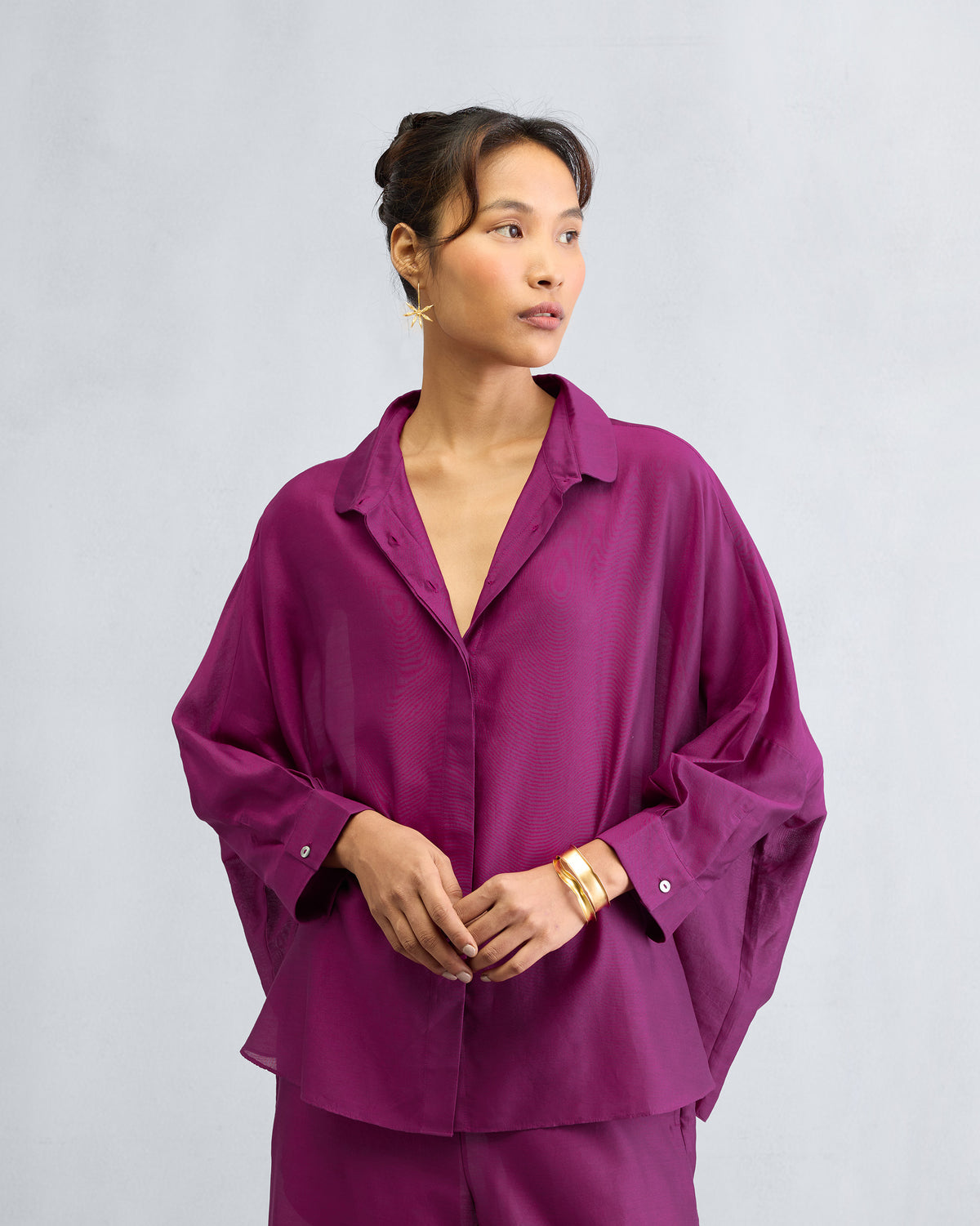 Mulberry boxy shirt worn open at the collar with voluminous sleeves.