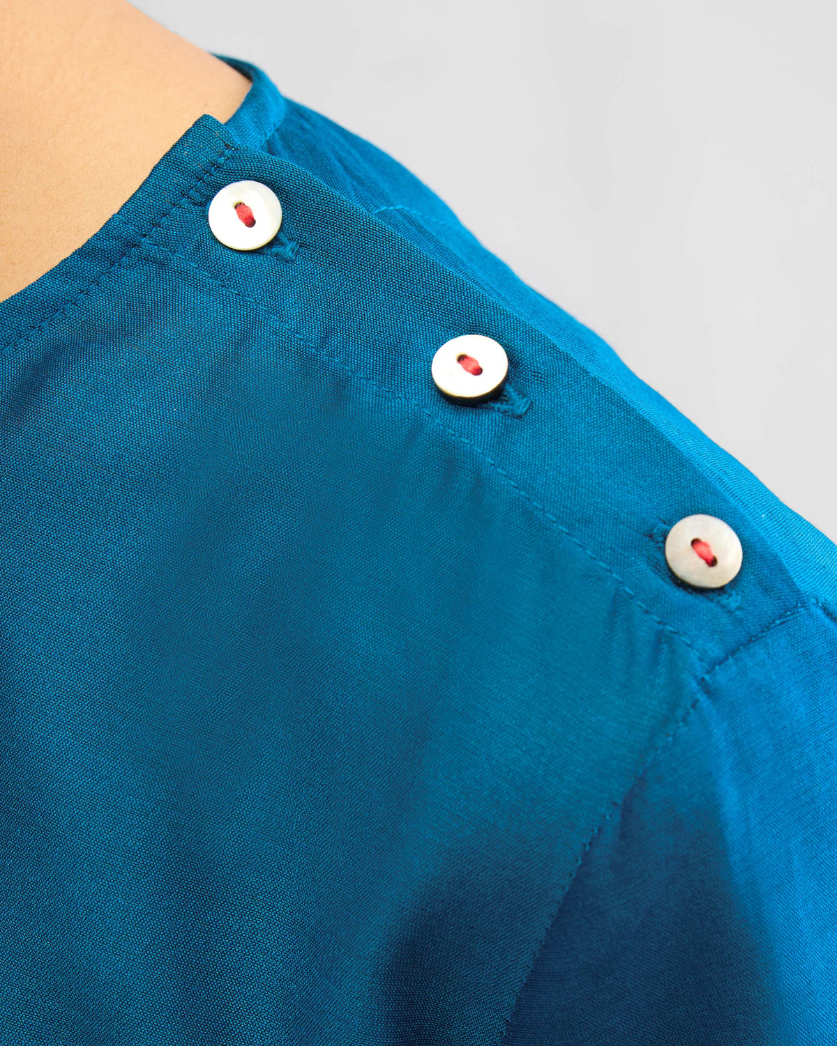 Close-up of the High Slit Top Set showing small buttons at the shoulder.