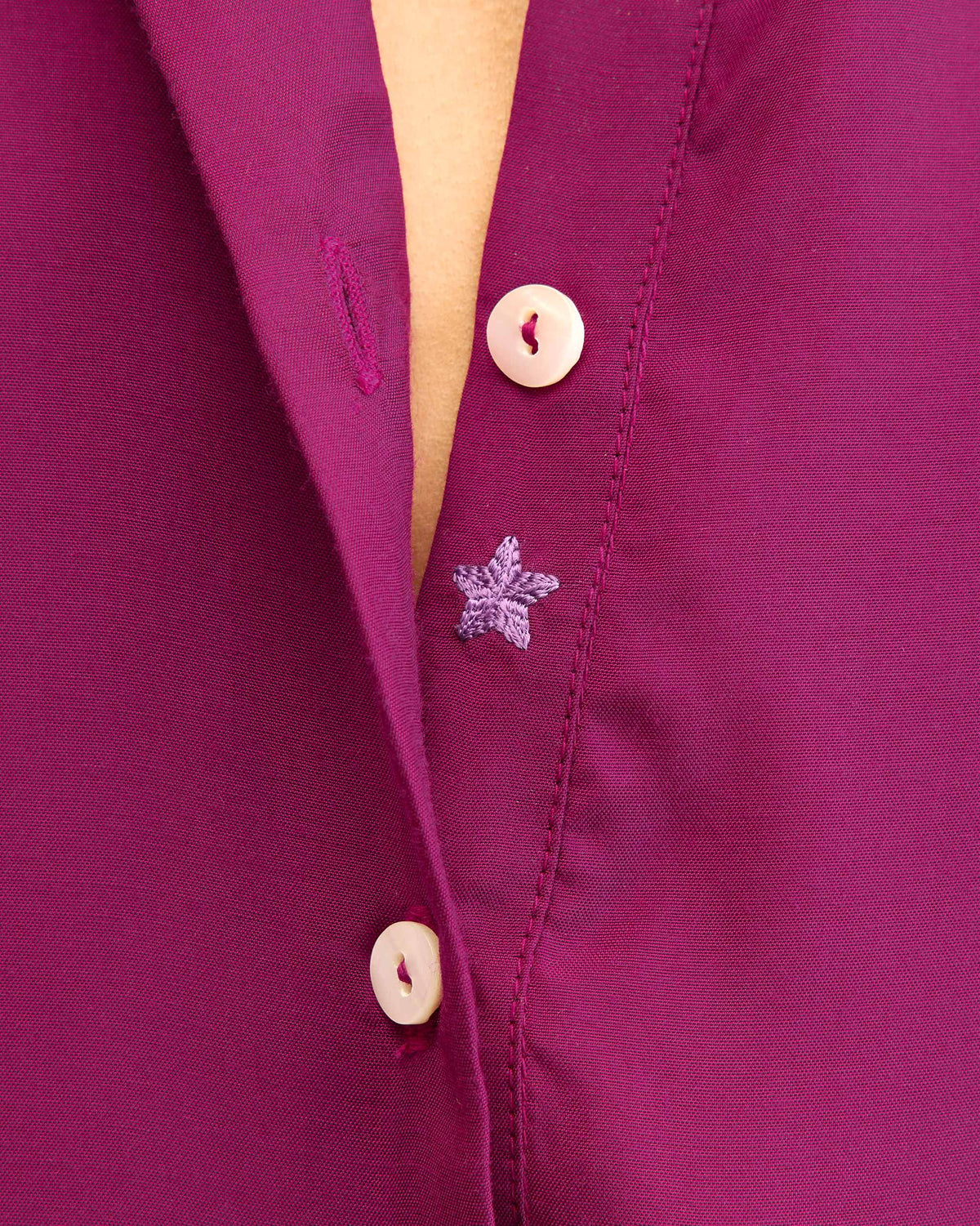 Close-up of a star embroidered on the mulberry kurta placket.
