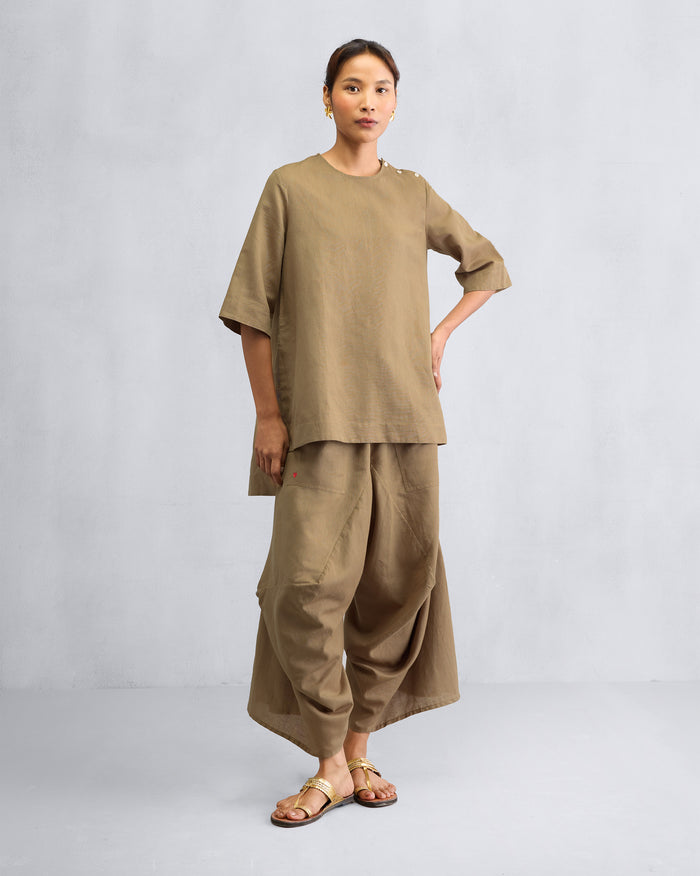 Person wearing the High Slit Top Set in taupe with wide draped pants.