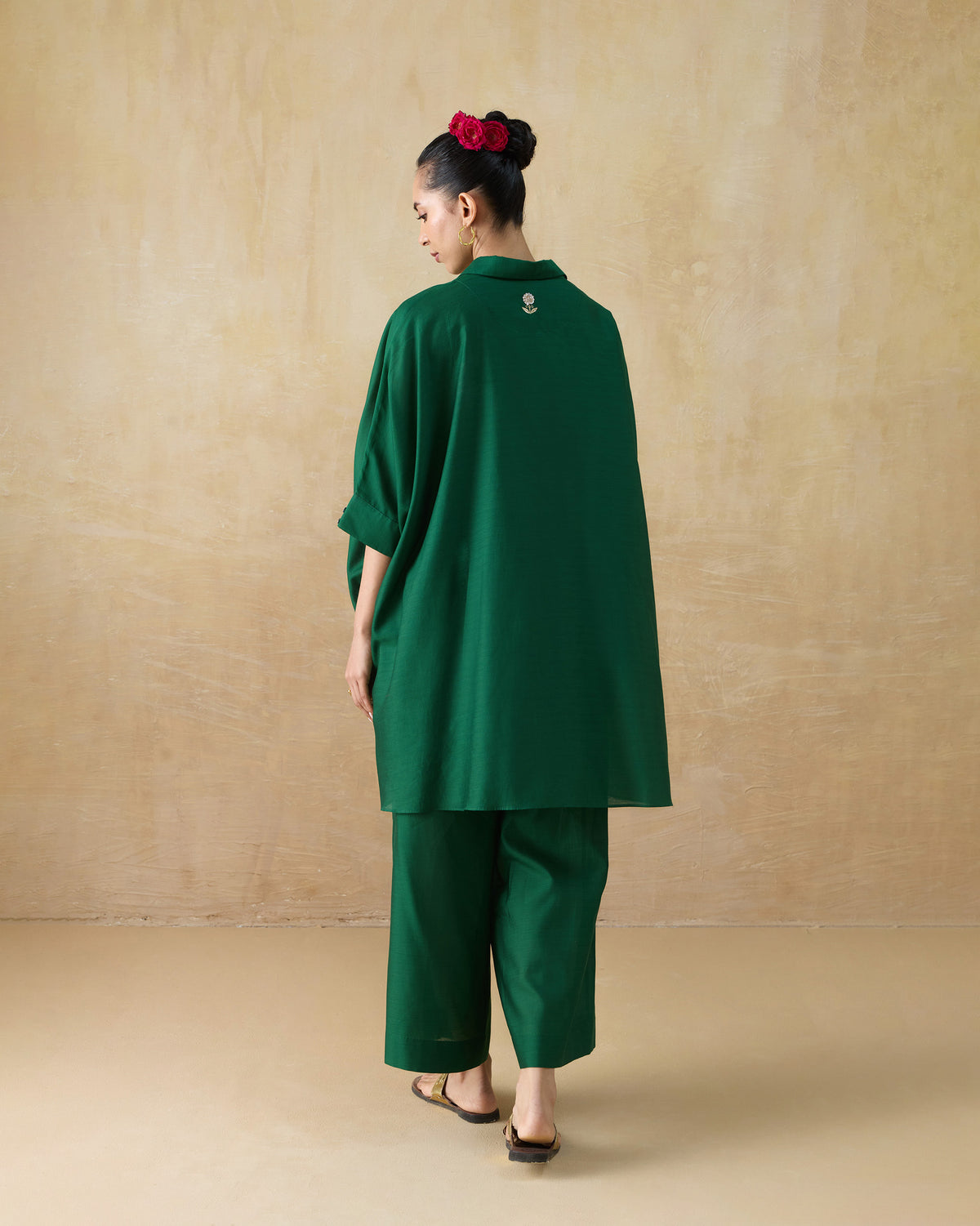 Back of an emerald green Hala tunic with a small floral embroidery.
