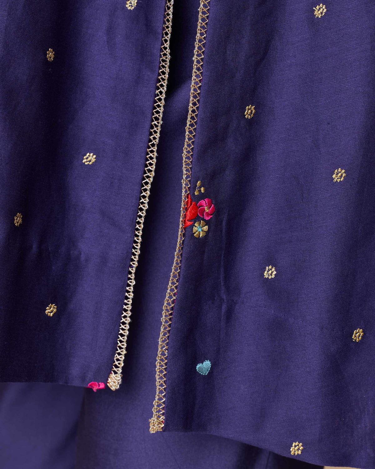 Close-up of gold lace trim and florals on a purple Nebula Kurta.
