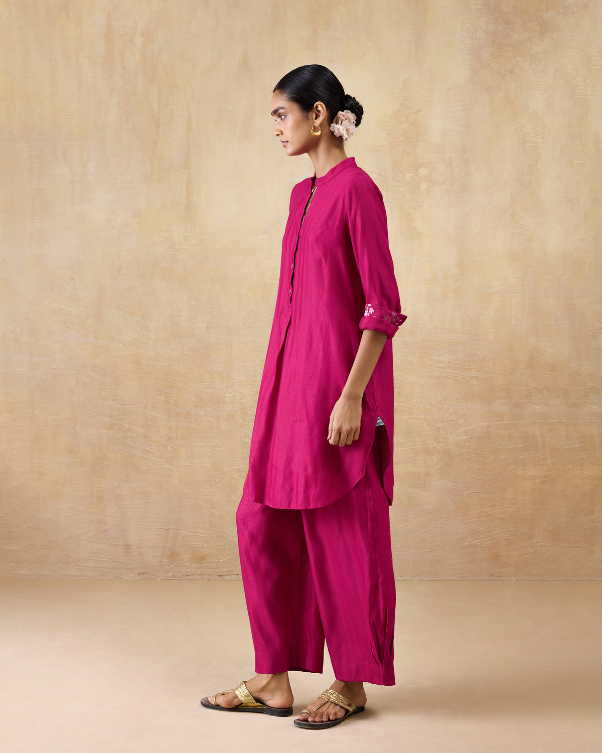 Side view of a berry pink long kurta set with side slits.